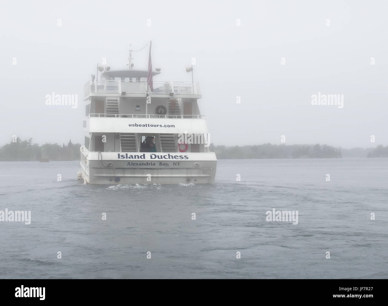 Alexandria Bay, New York, USA. June 27, 2017. Pouring rain and fog on The Saint Lawrence Seaway with tour boat heading for Boldt and Singer castles an Stock Photo