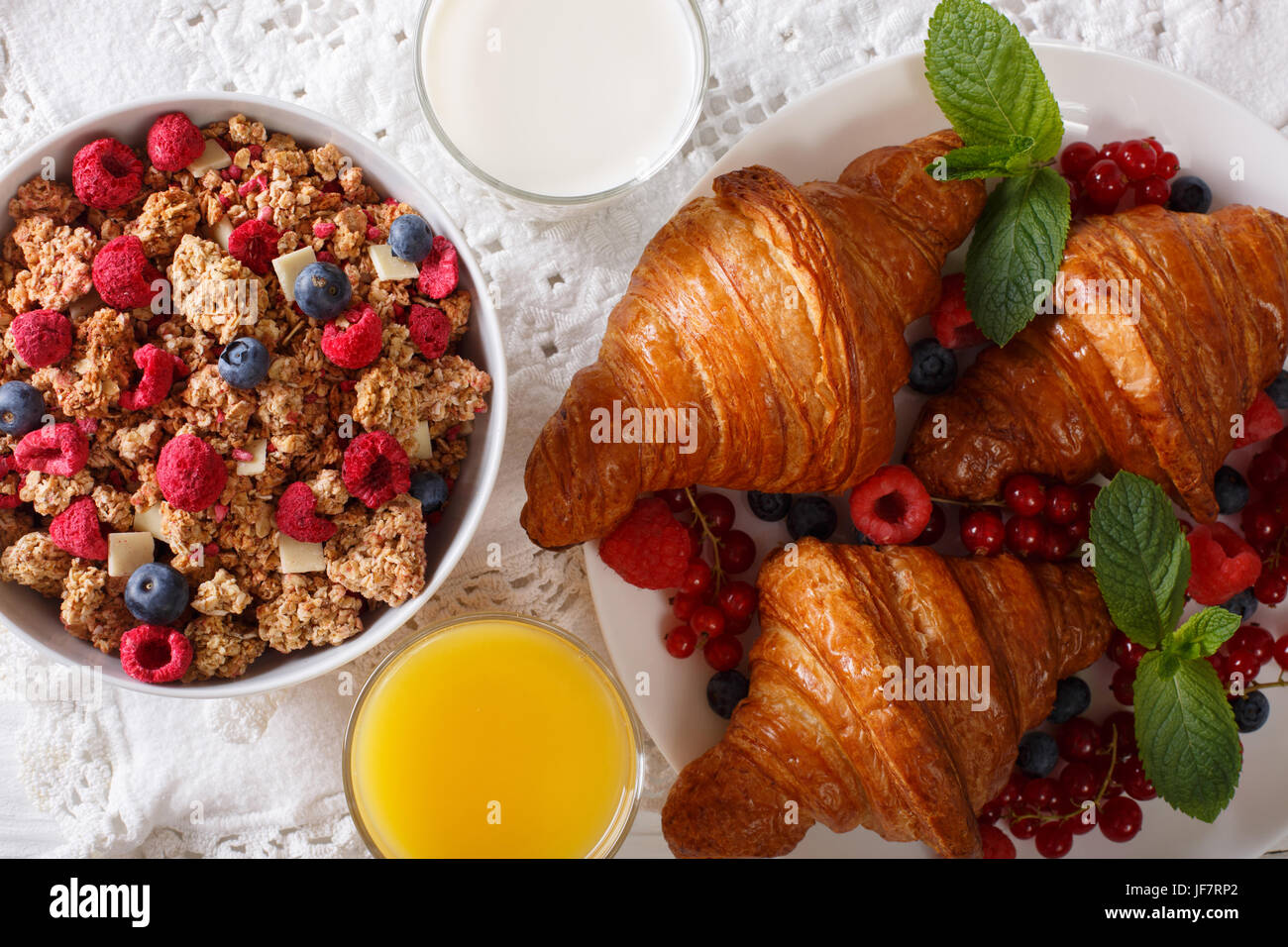 Healthy food: granola, croissants, fresh berries, milk and orange juice close-up on the table. horizontal view from above Stock Photo