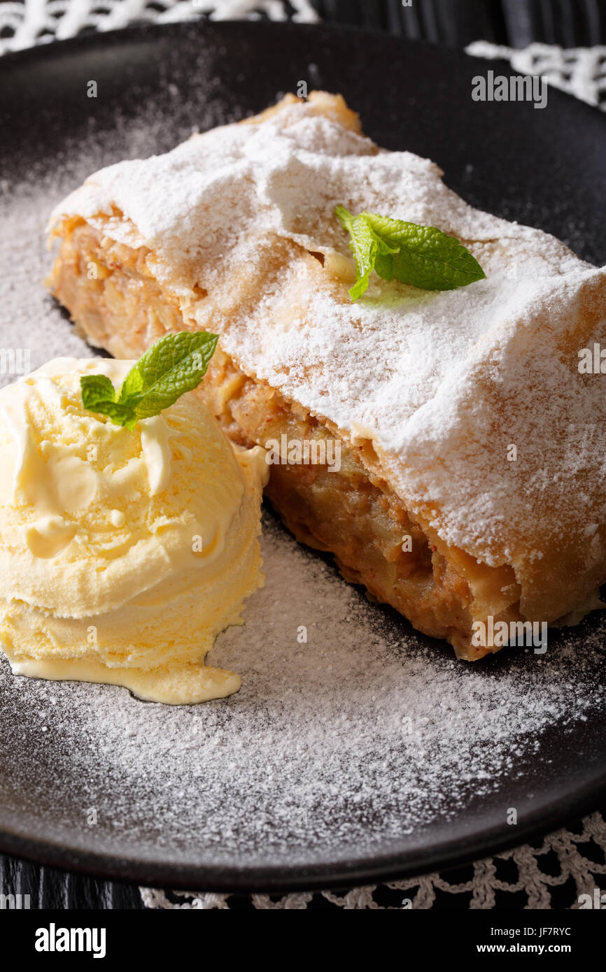 Austrian traditional apple strudel with ice cream and mint closeup on a plate. vertical Stock Photo