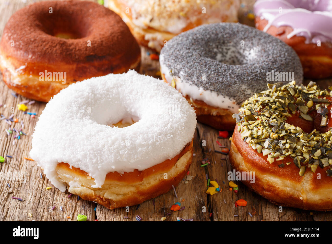 Delicious glazed multicolored donuts close-up on a table. horizontal Stock Photo