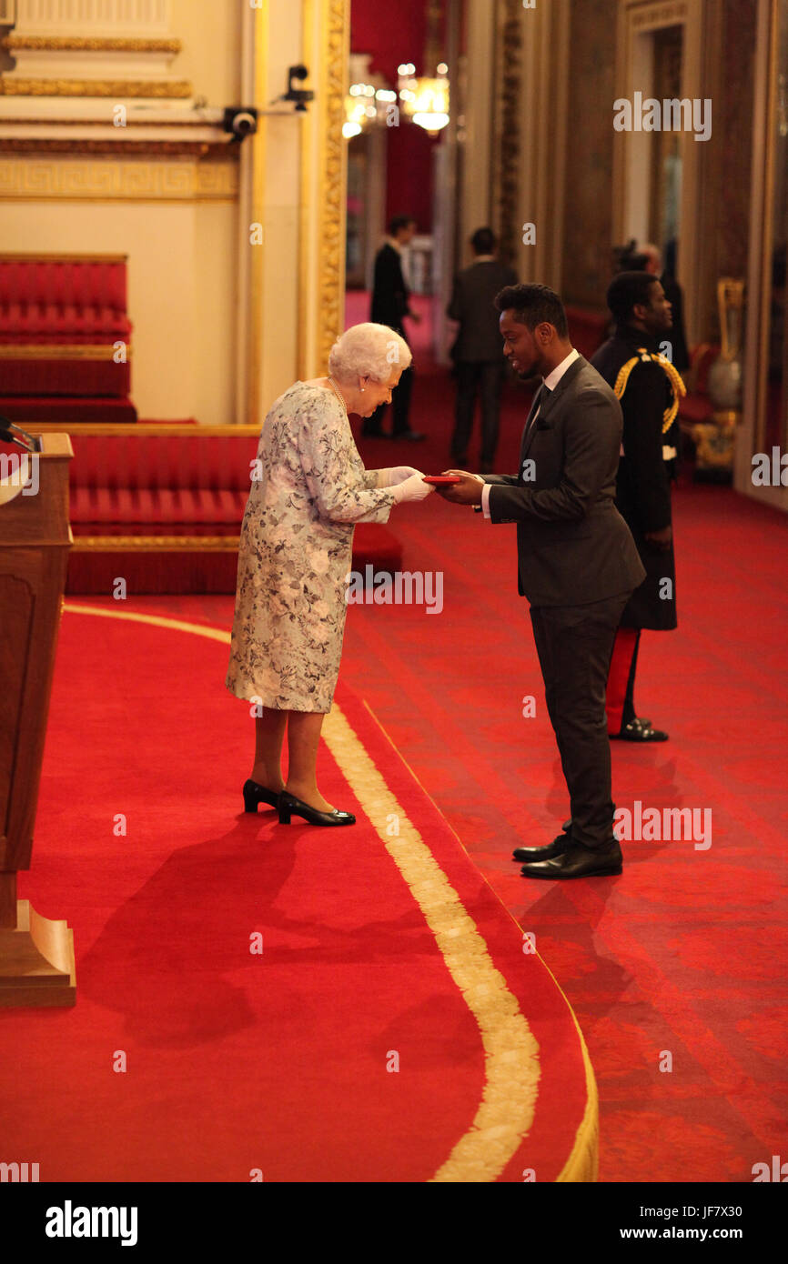 Abdullahi Alim from Australia receives a Queen's Young Leaders Award for 2017 from Queen Elizabeth II during a ceremony at Buckingham Palace in London. Stock Photo