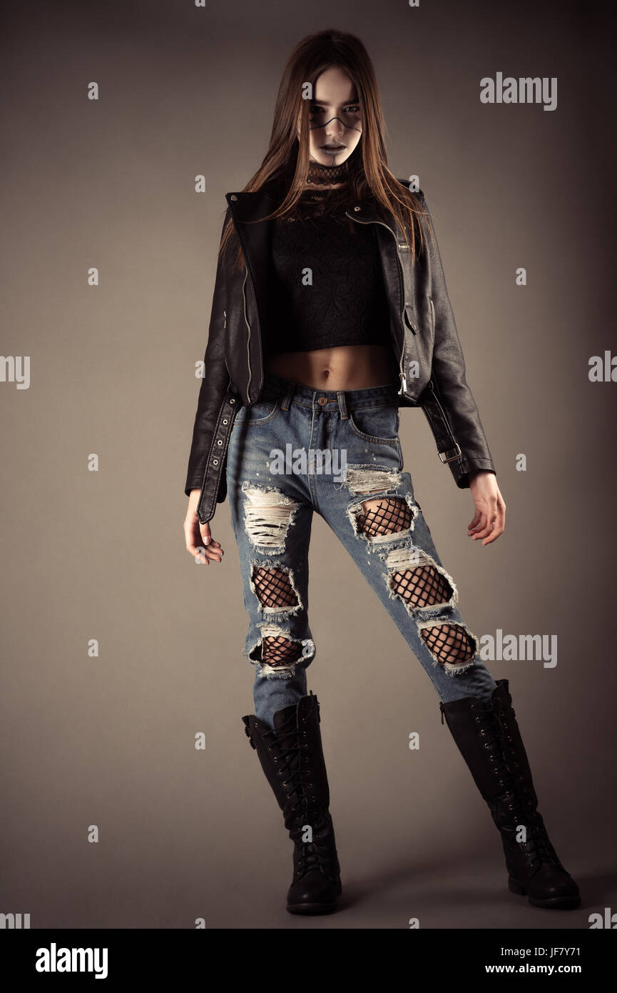fashionable teenager girl in leather jacket and torn jeans Stock Photo