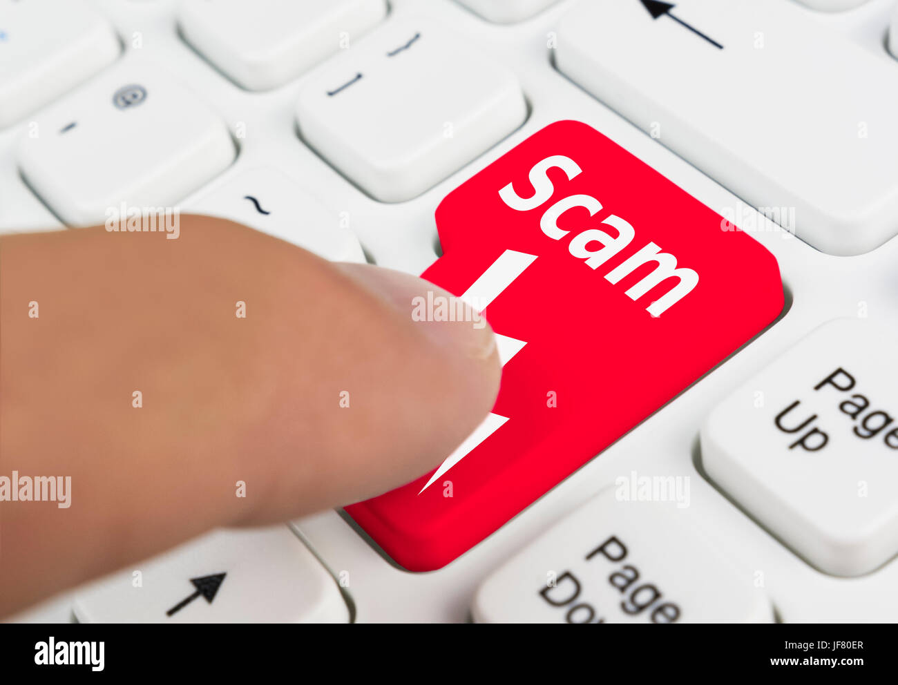 Scam concept. Finger pressing a scam button on a computer keyboard. Stock Photo