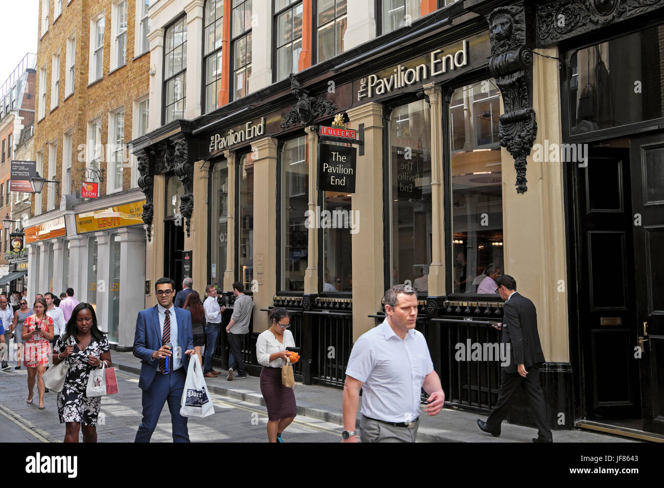 Businessmen and businesswomen walking near The Pavilion End pub in Watling Street at lunchtime in the City of London EC4 England UK  KATHY DEWITT Stock Photo