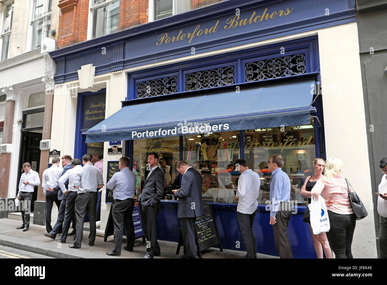 Businessmen and women queuing for food outside Porterford Butchers shop at lunchtime Watling Street in the City of London EC4 England UK  KATHY DEWITT Stock Photo