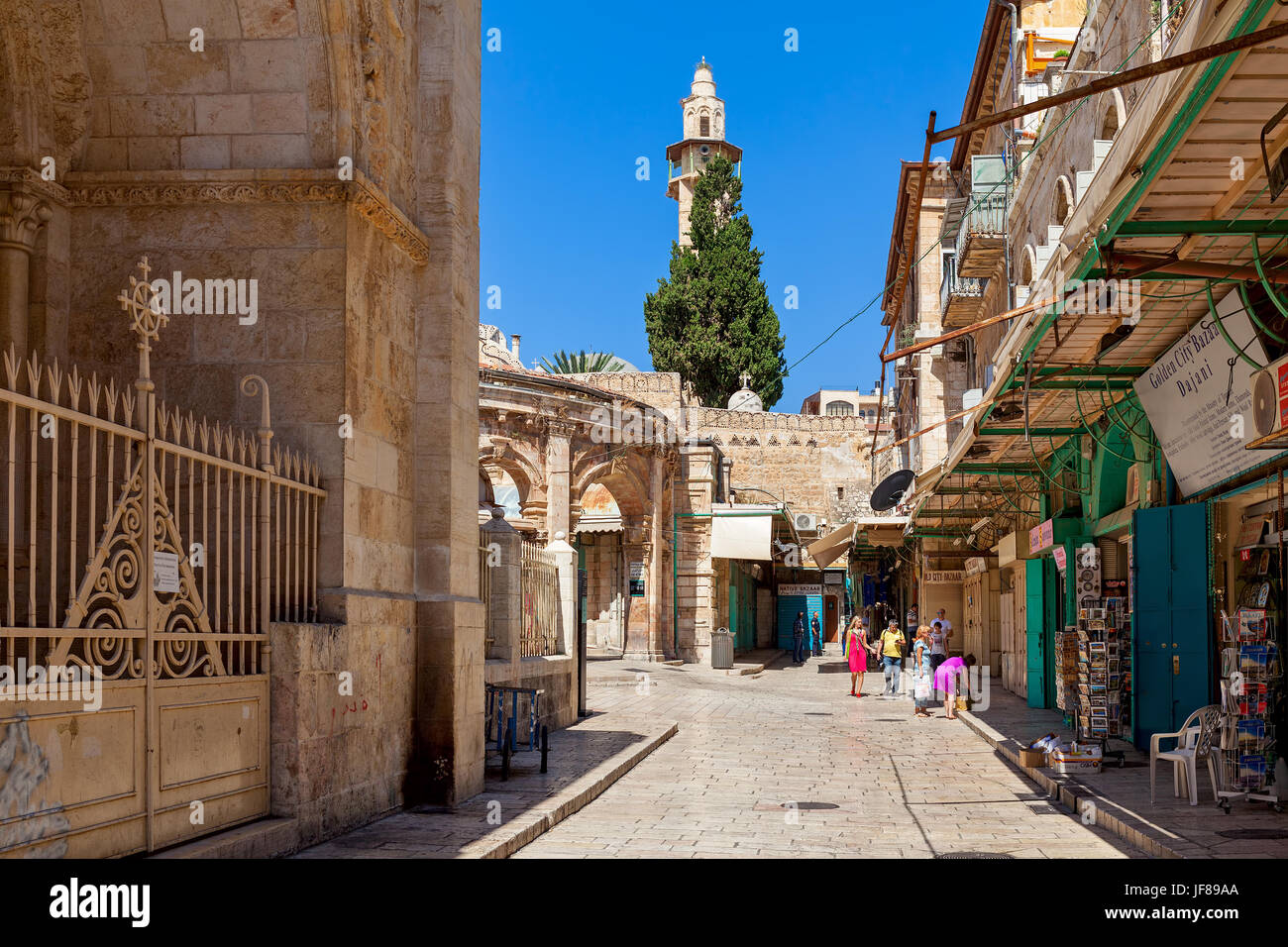 JERUSALEM, ISRAEL - JULY 04, 2016: Narrow street with souvenir shops as minaret on background in Muristan  - christian quarter, popular tourist destin Stock Photo