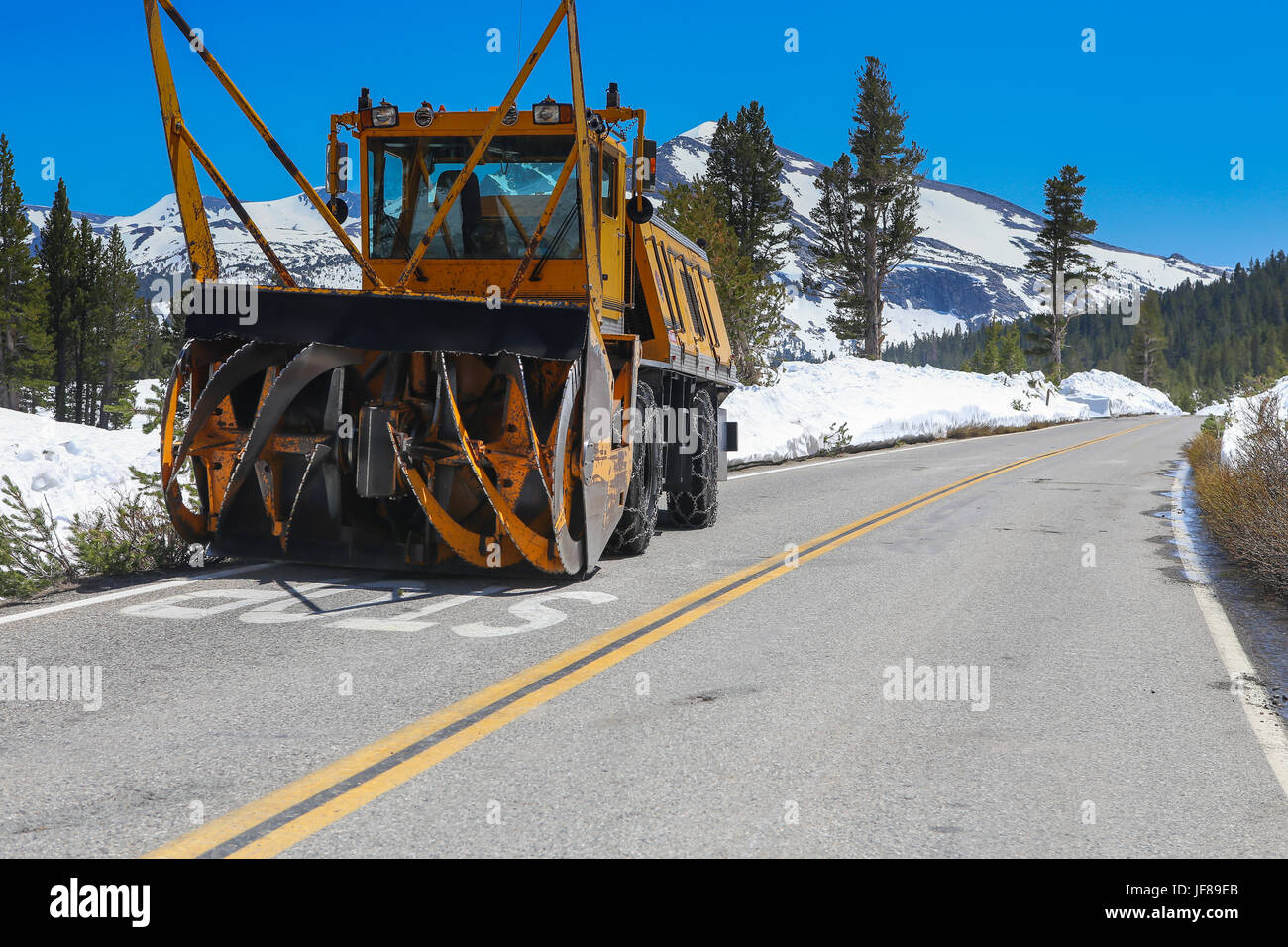 Snow blower with spinning blades used for removing snow from the road on  the Tioga Pass Sierra Nevada California USA Stock Photo - Alamy