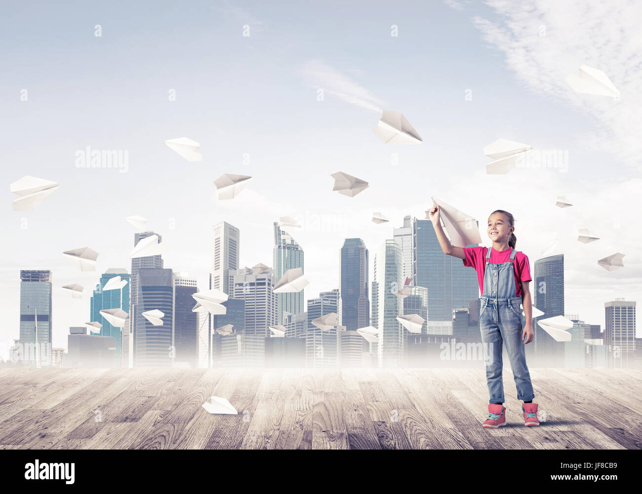 Cute kid girl stand on wooden floor and paper planes flying around ...
