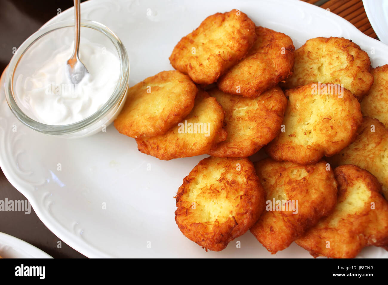 Tasty potato pancakes with sauce on white plate, closeup Stock Photo