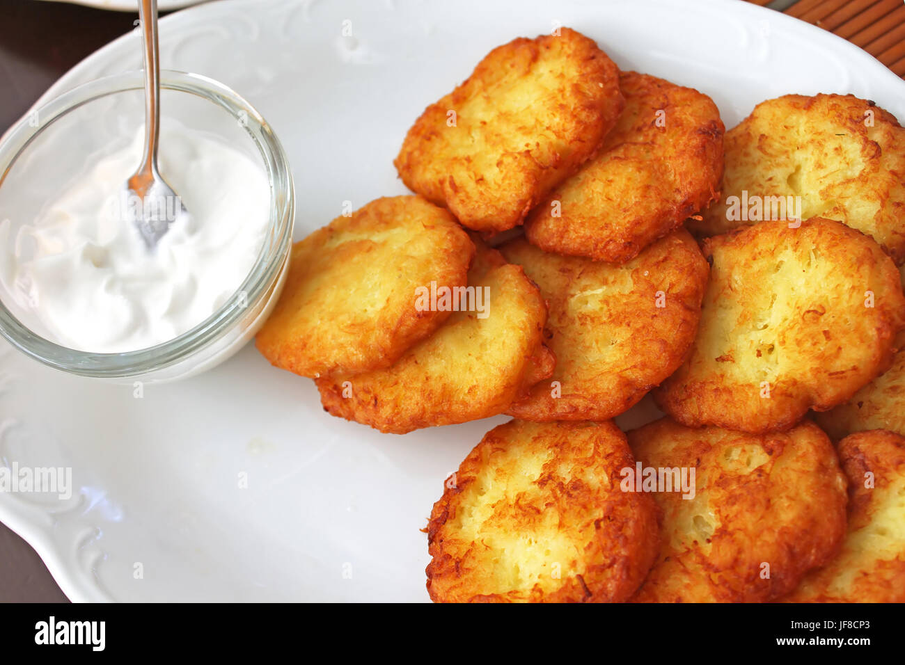 Tasty potato pancakes with sauce on white plate, closeup Stock Photo