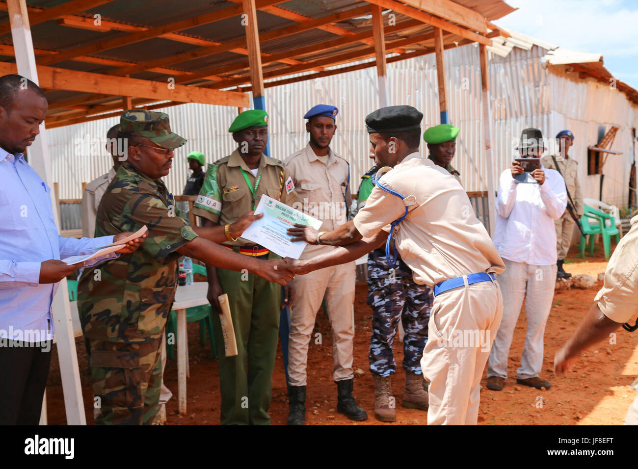 A Somali Police officer receives a certificate after attending the close-protection course conducted by AMISOM Police in Kismayo, Somalia on May 20, 2017. AMISOM Photo Stock Photo