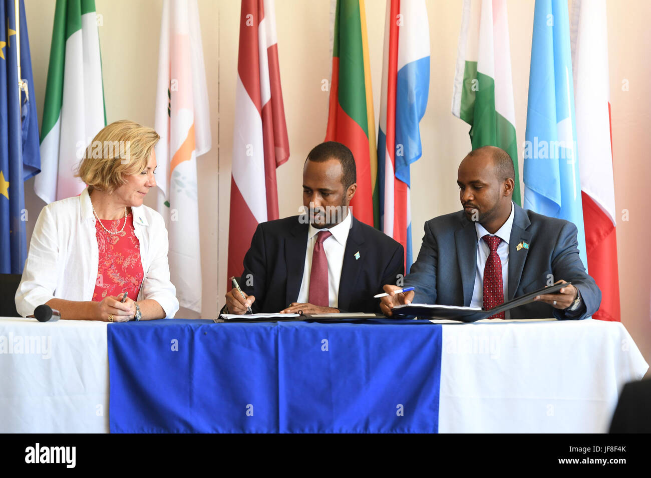 Jamal Mohamed Hassan, Minister of Planning, investment and economic promotion of the Federal Government of Somalia (center) and Veronique Lorenzo, the European Union (EU) Ambassador to Somalia, sign Agreement during celebrations to mark Europe Day in Mogadishu on May 09, 2017. AMISOM Photo / Omar Abdisalan Stock Photo