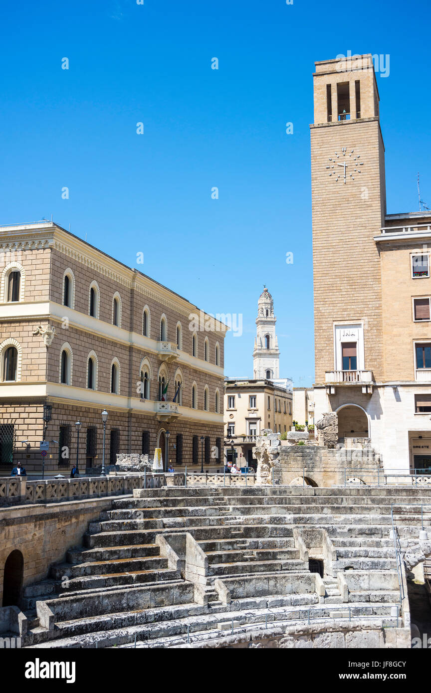 Lecce, Italy. the roman amphitheatre with the INA building on right and duomo campanile in the background. Stock Photo