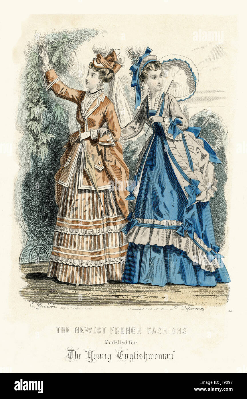 The newest French fashions modelled for The 'Young Englishwoman'.  Hand coloured fashion plate.  Women modellling full length summer dresses and lightweight long  jackets with bustles at back. One holds parasol .  Engraved by E.Gourdon.  published by Ad.Goubaud, Paris Stock Photo