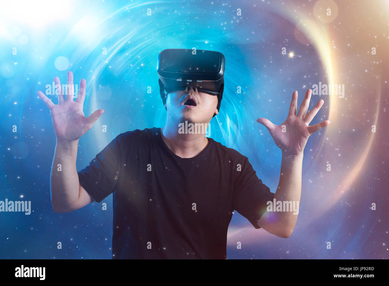 The young man wearing virtual reality goggles with amazing cosmic ...