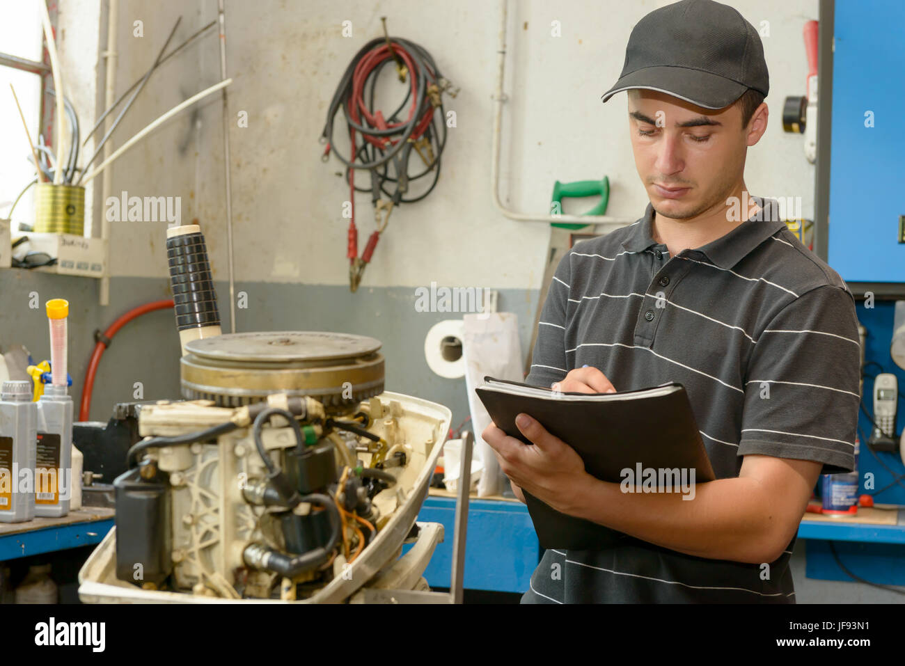 a young mechanic checking the small boat engine Stock Photo Alamy