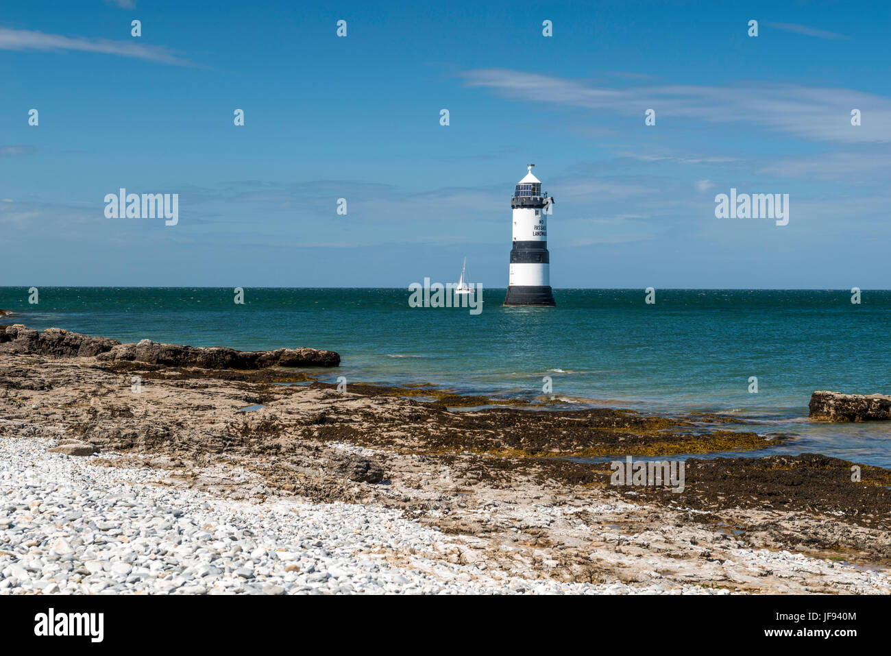 Beautiful seascape depicting Penmon Lighthouse and surrounding coastal features, (Trwyn Du, Perch Rock, Ynys Seiriol, Puffin Island) on a summers day. Stock Photo