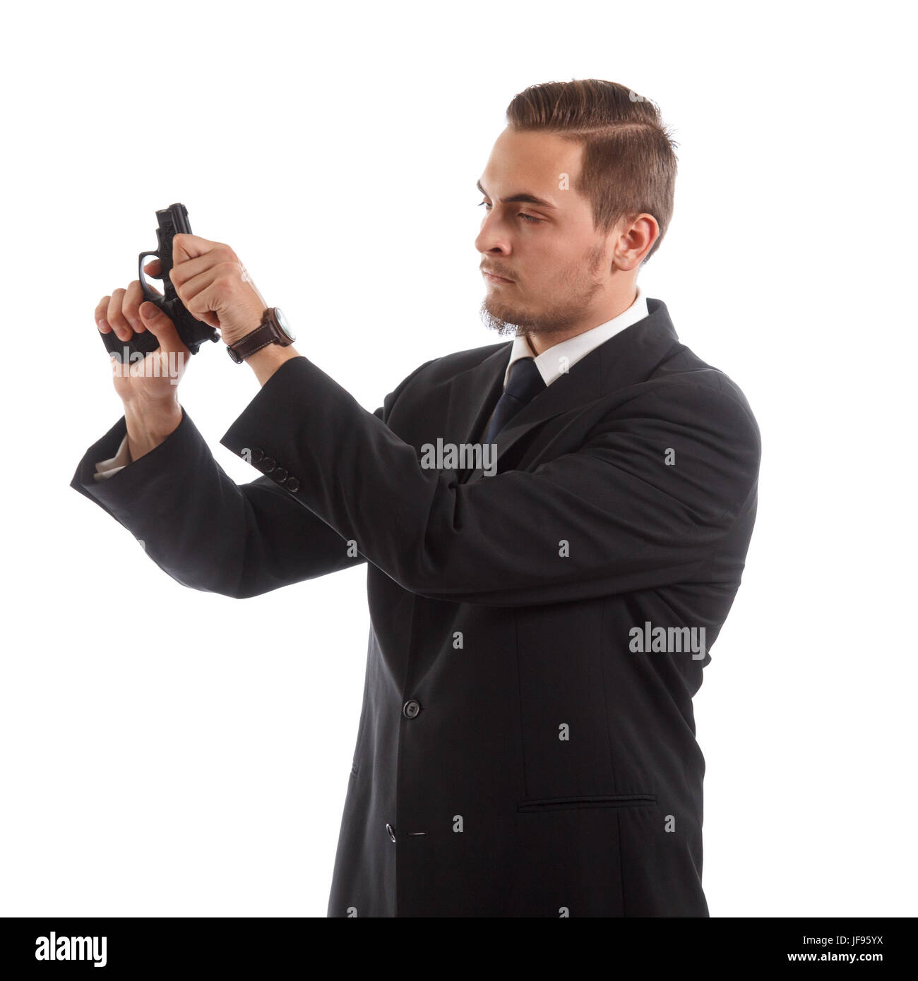 A man in a suit reloading a handgun Stock Photo - Alamy