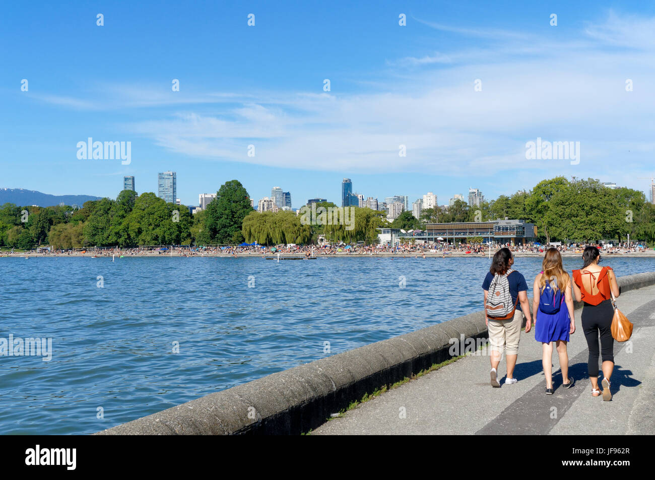 Three young women walking on the Kitsilano seawall path with Kitsilano