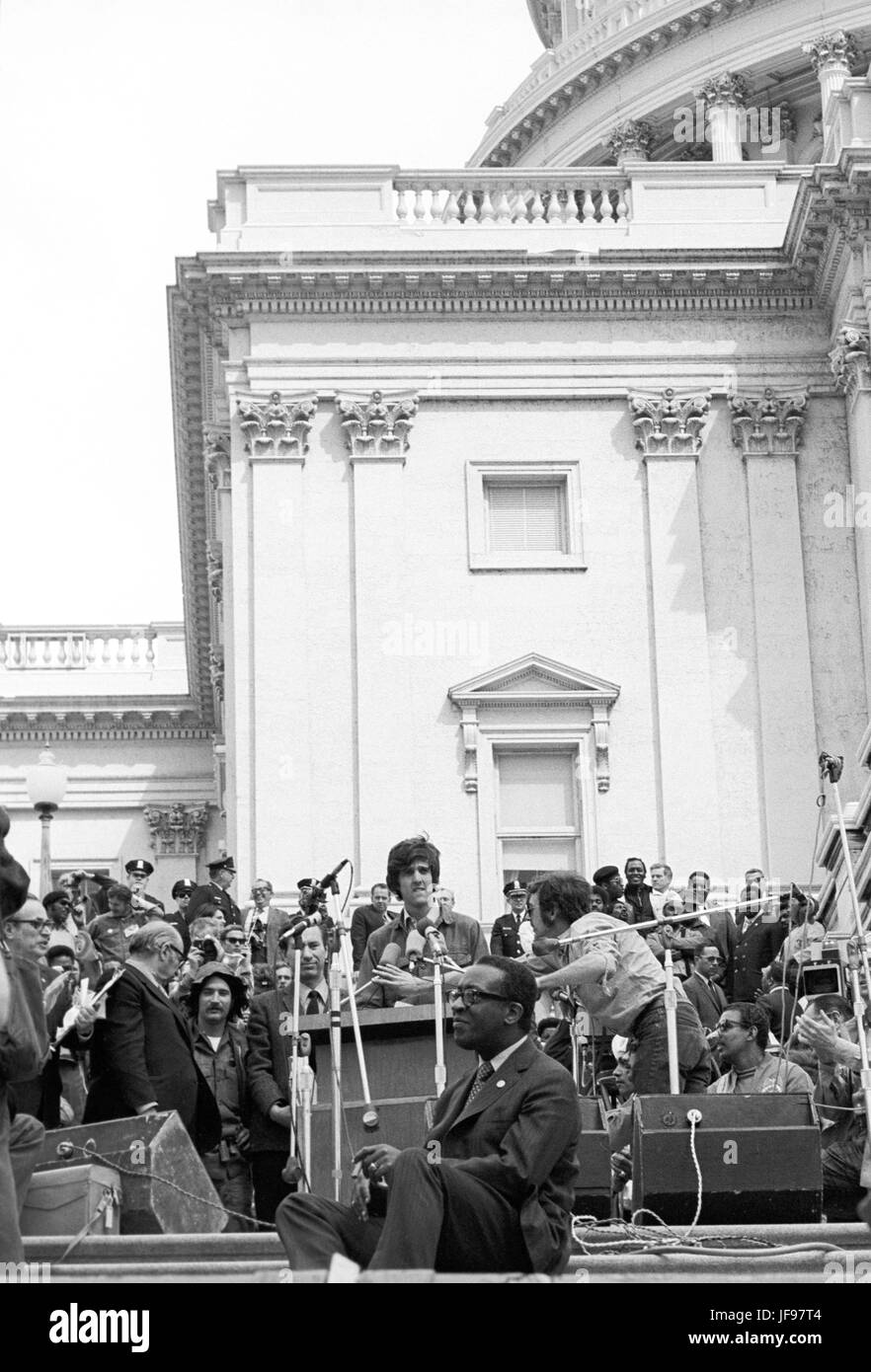 On April 22, 1971, Vietnam veteran Lt. John Kerry became the first Vietnam veteran to testify before Congress about the war, when he appeared before a Senate committee hearing on proposals relating to ending the war. Kerry is shown here at the speaker's podium on the U.S. Capitol steps the day after his testimony - April 23, 1971 - as he participated in a demonstration with thousands of other veterans in which he and other veterans threw their medals and ribbons over a fence erected at the front steps of the United States Capitol building to dramatize their opposition to the war. Stock Photo