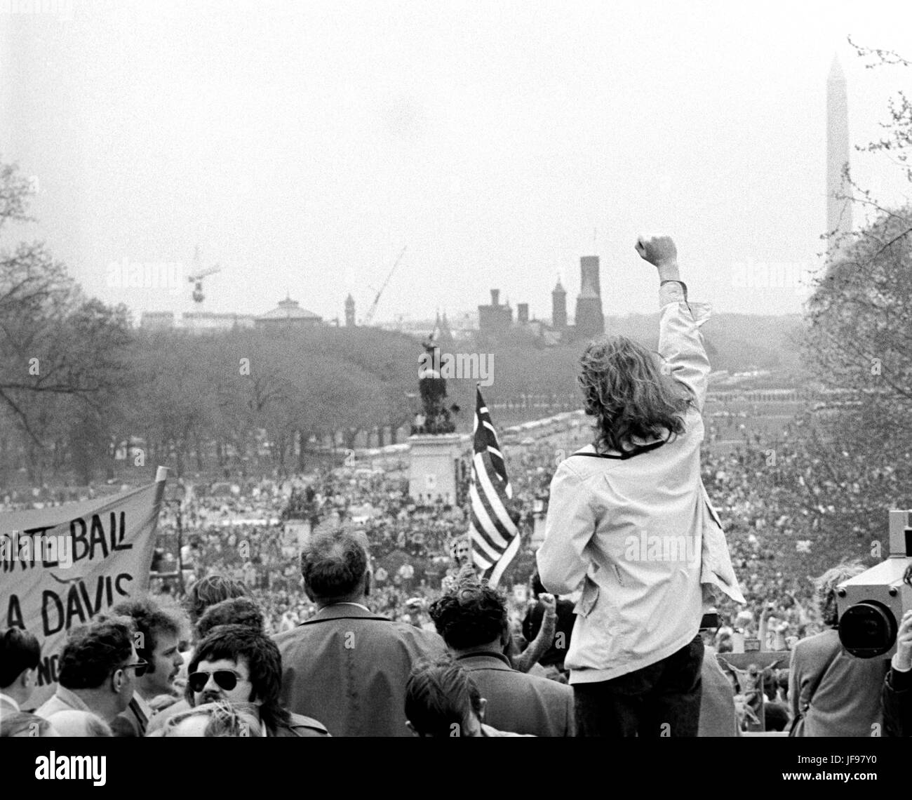 A demonstrator raises a clenched fist toward antiwar protestors on the U.S. Capitol grounds and the Mall during massive demonstrations against the Vietnam war on April 23, 1971 as Lt. John Kerry prepares to speak. Stock Photo