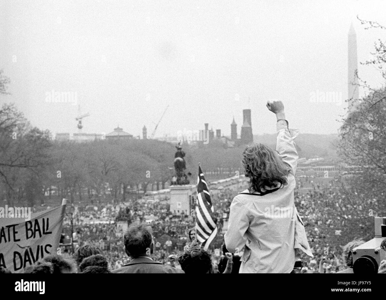 A demonstrator raises a clenched fist toward antiwar protestors on the U.S. Capitol grounds and the Mall during massive demonstrations against the Vietnam war on April 23, 1971 as Lt. John Kerry prepares to speak. Stock Photo