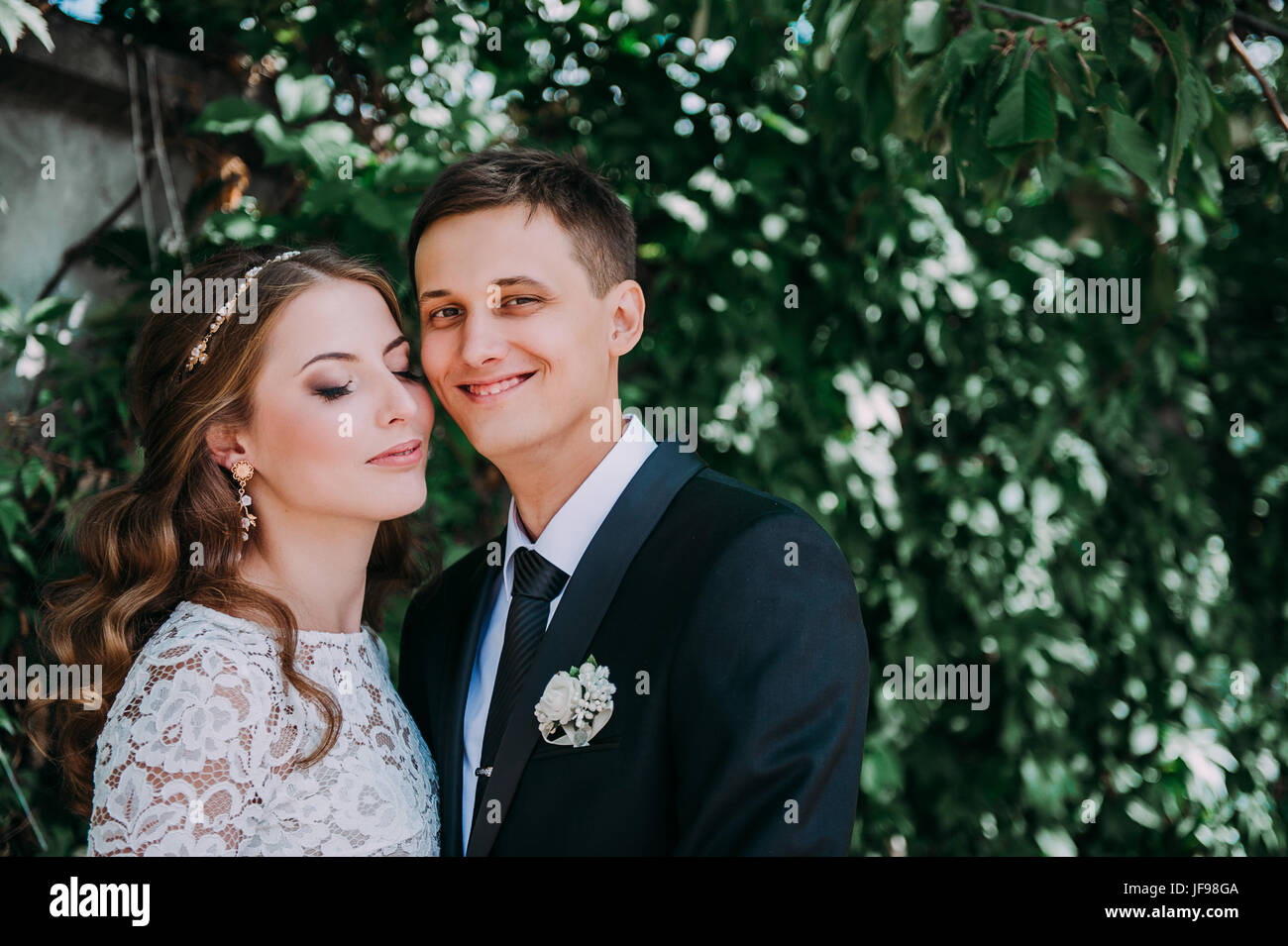happy bride and groom at a park on their wedding day Stock Photo - Alamy