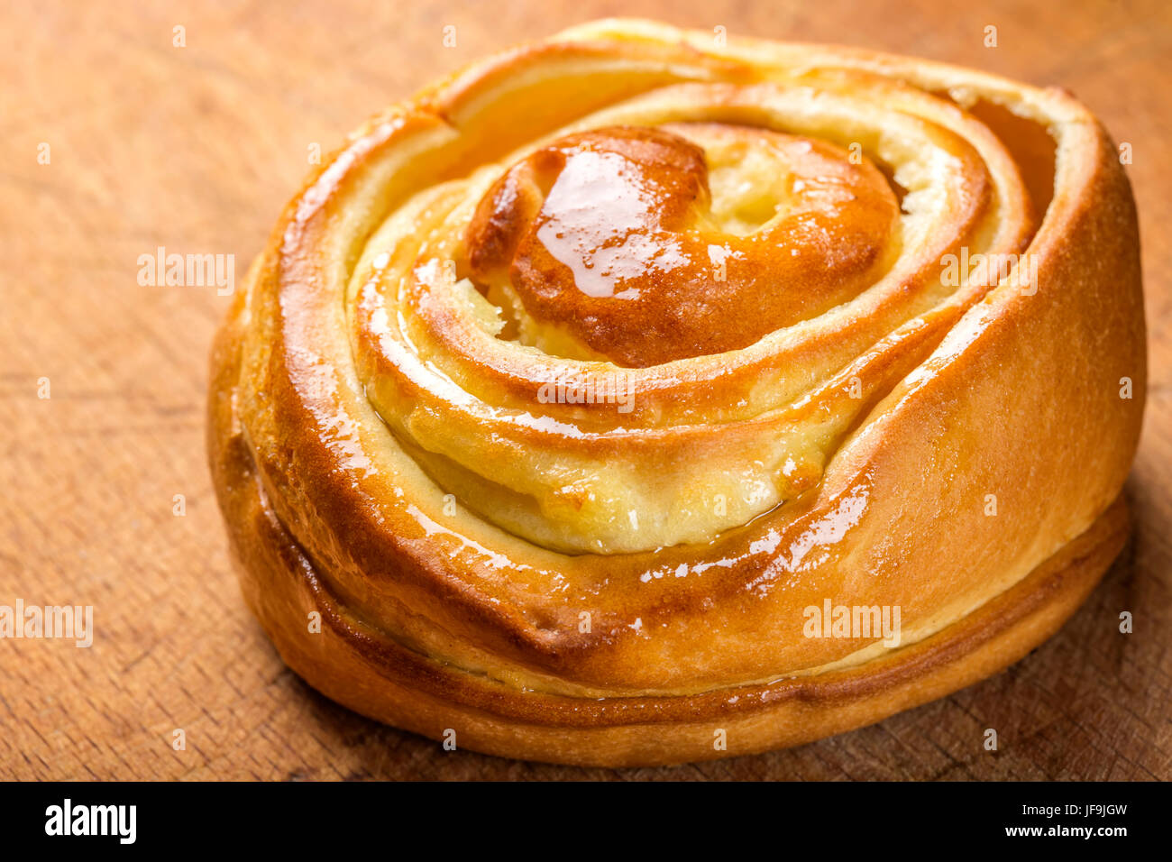 Close up of fresh sweet homemade cinnamon roll. Svedish cuisine. Dark wood background Stock Photo