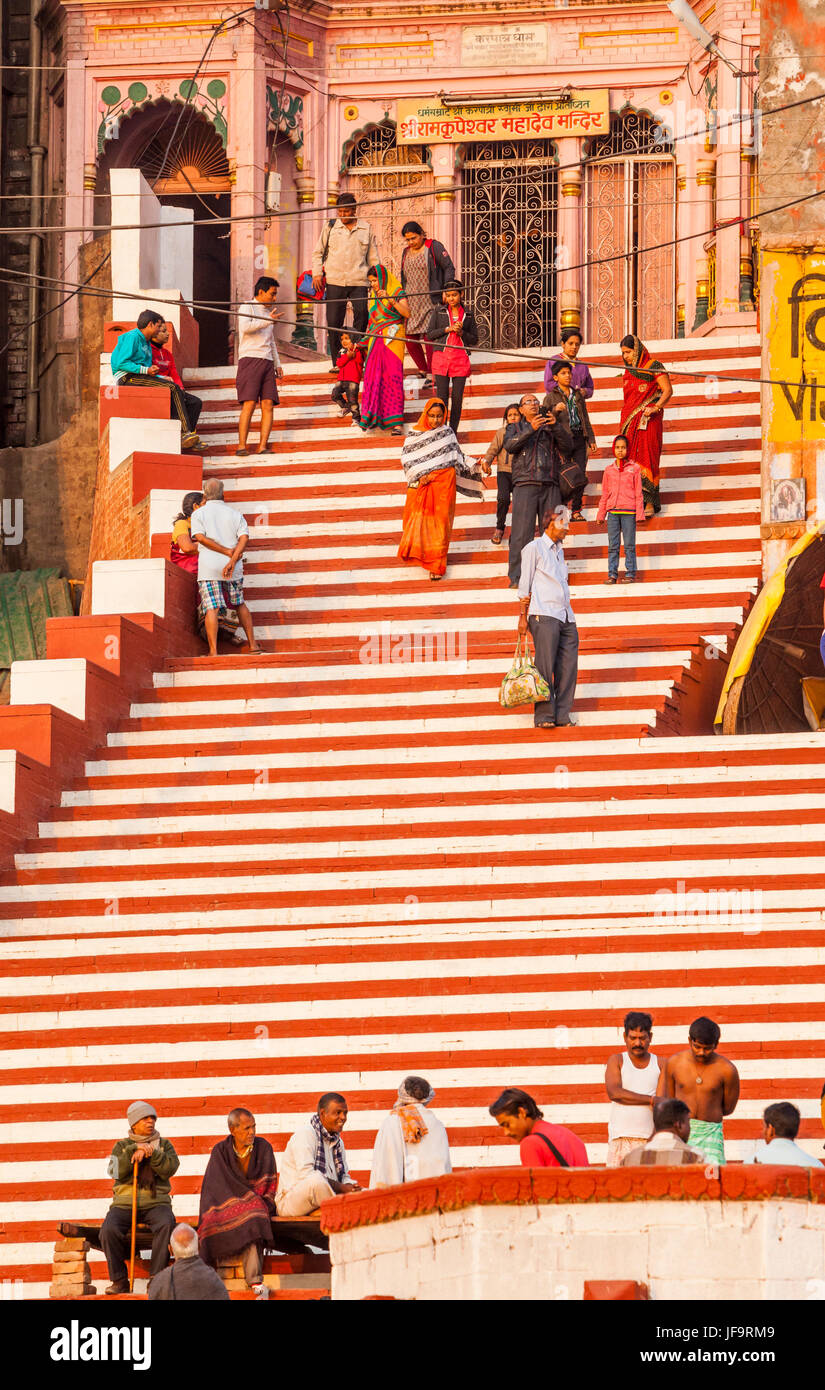 Families on the steps of a ghat in Varanasi along the shores of the Ganges river, a very holy place for Hindus in India. Stock Photo