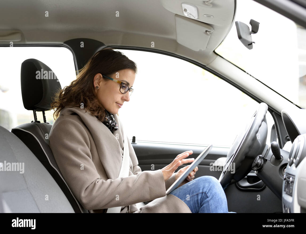 businesswoman with digital tablet in the car Stock Photo