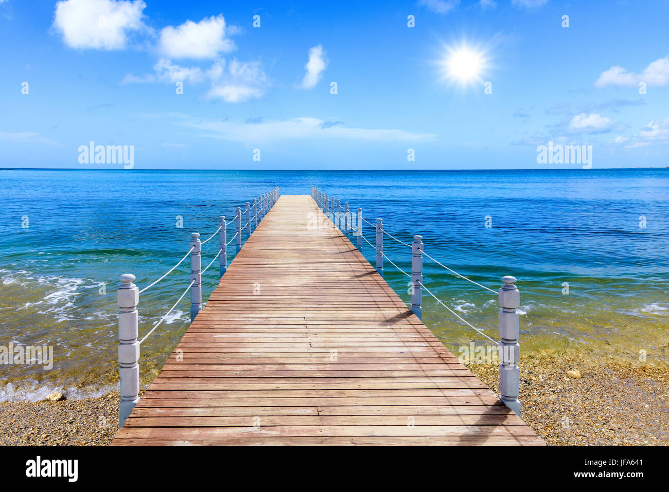 wooden bridge juts out into  of the sea Stock Photo