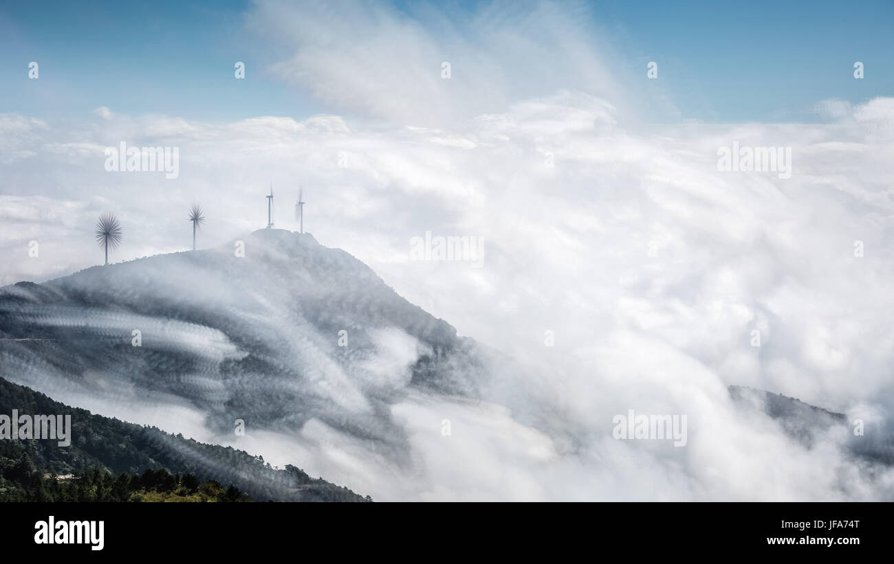 mountain top of wind farms with clouds Stock Photo