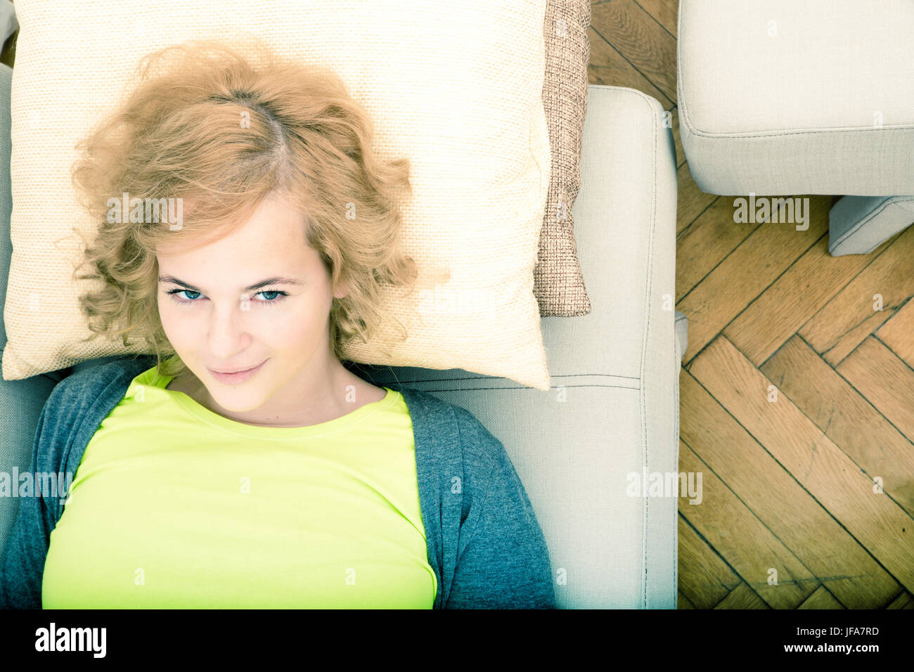 A young smiling woman relaxing on the sofa Stock Photo - Alamy