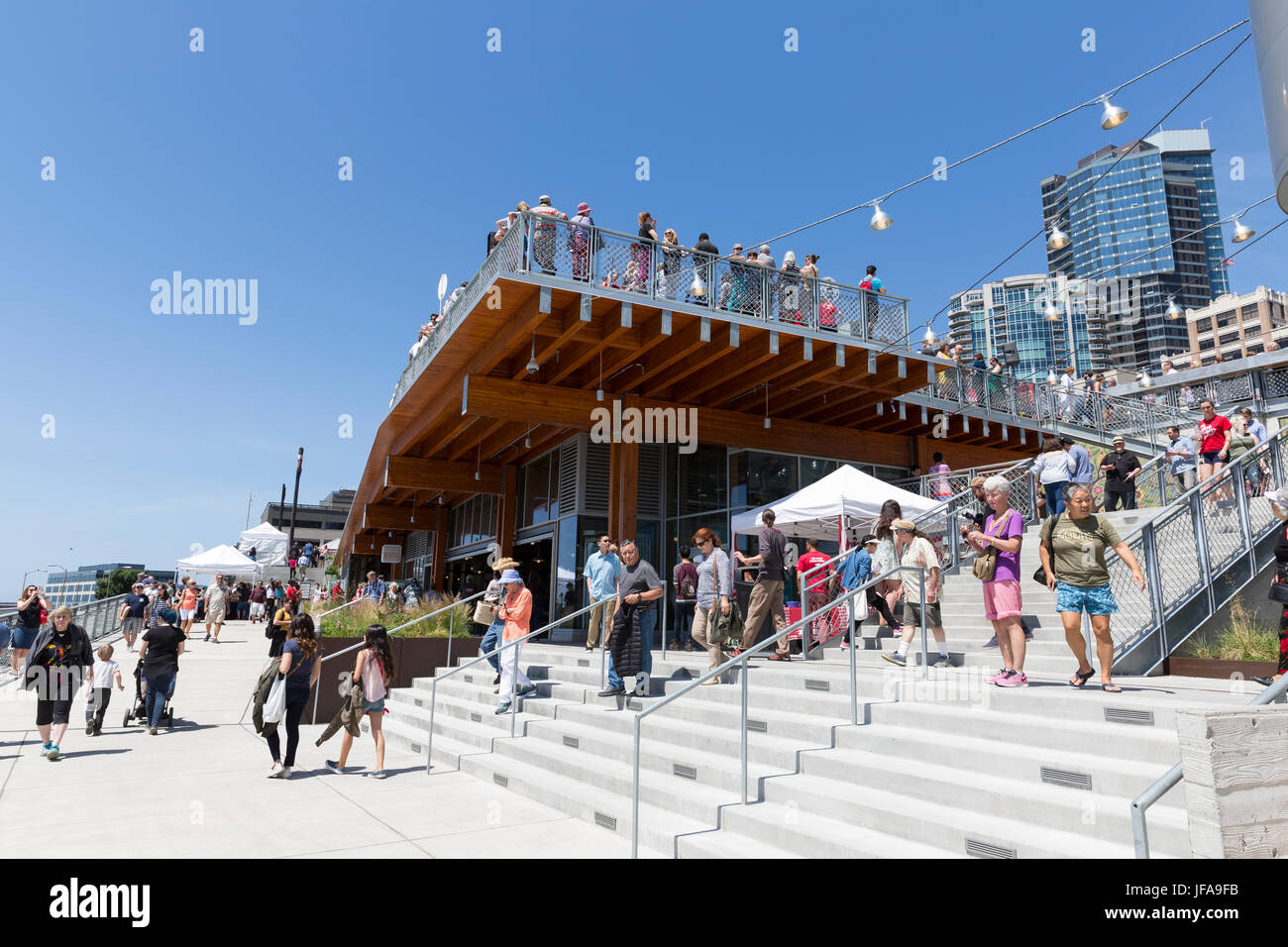 Seattle, United States. 29th June, 2017. Seattle, Washington: Historic Pike Place MarketFront had its grand opening under a warm summer sun. The $74 million MarketFront expansion provides a dynamic public plaza with views of Puget Sound and Olympic Mountains as well as table space for farmers, craftspeople and artisan purveyors, retail space, low-income housing, a neighborhood center and parking. The project was created in accordance of Market historic district guidelines and the Pike Place Market charter. Credit: Paul Christian Gordon/Alamy Live News Stock Photo