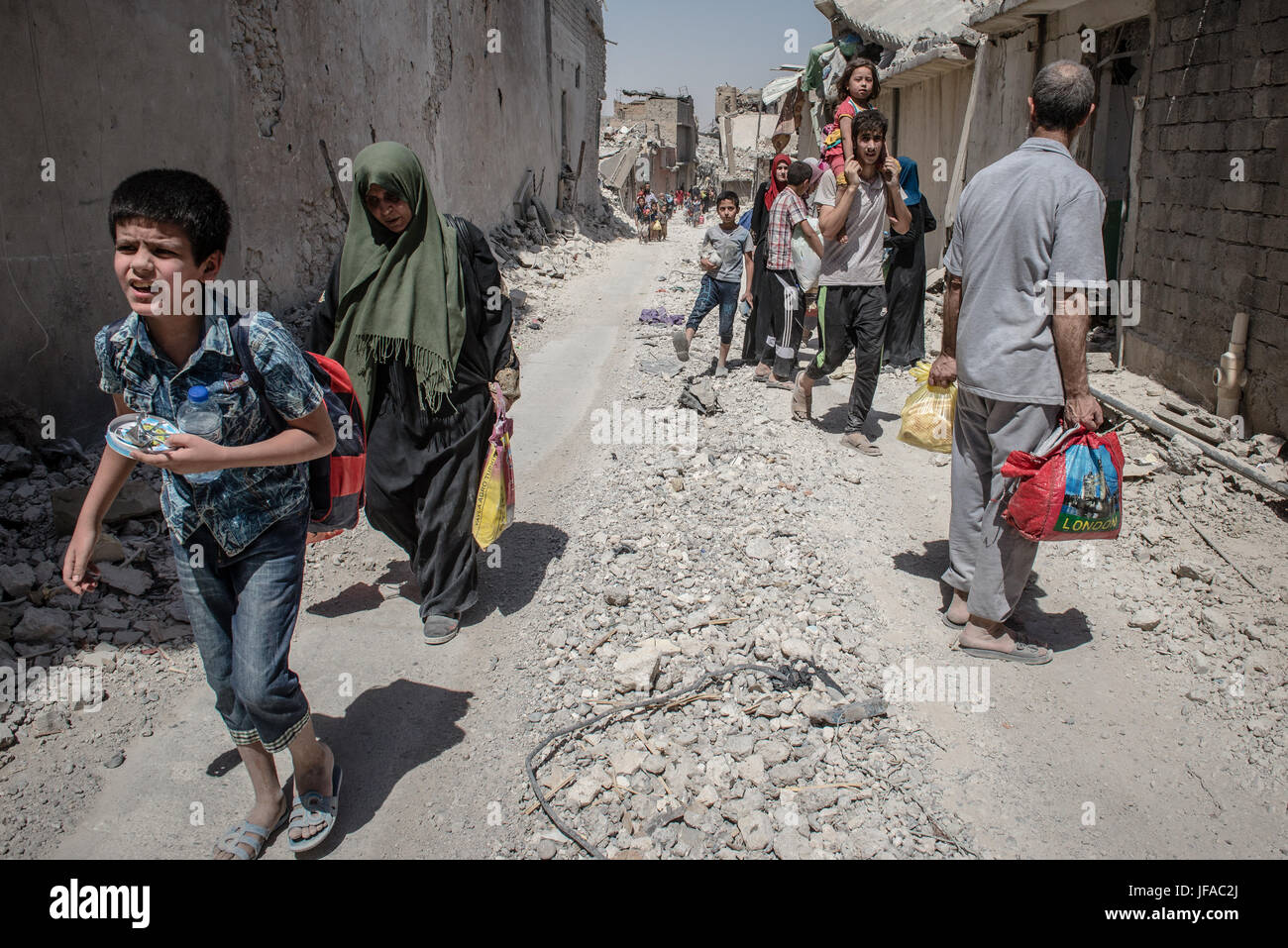 Iraqi civilians flee heavy fighting between Iraqi forces and the Islamic State in the Old City of Mosul, Iraq 29 June 2017.Thousands of civilians are fleeing the Old City towards IDP (Internal Displaced People) camps, According to UNHCR, more than 875,000 people have fled Mosul since the beginning of the fighting in October 2016. Photo: Hugo Passarello Luna/Dpa/dpa Stock Photo