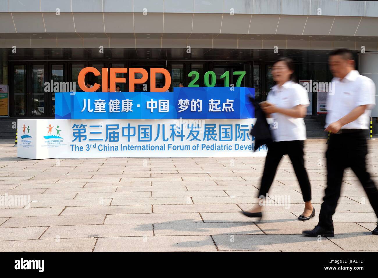 Beijing, China. 30th June, 2017. People walk past a signboard of the 3rd China International Forum of Pediatric Development (CIFPD) in Beijing, capital of China, June 30, 2017. The every-two-year CIFPD, under the theme 'Children's Health, the Starting Point of the Chinese Dream', is devoted to advancing international pediatric development, exchanges and collaborations. This year's CIFPD lasts from June 30 to July 2. Credit: Zhang Yuwei/Xinhua/Alamy Live News Stock Photo