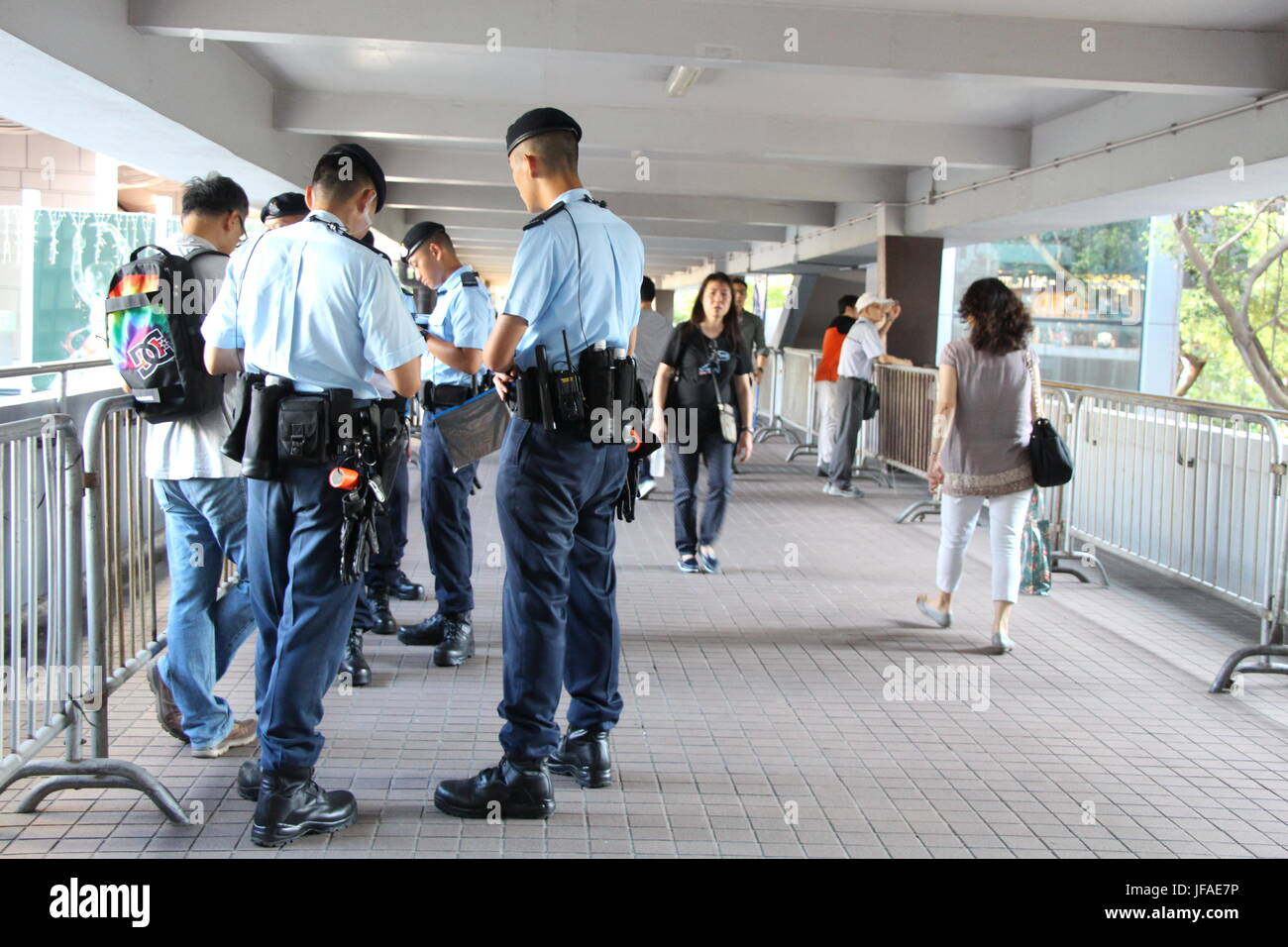 On the first day of President Xi Jinping's visit to Hong Kong, footbridges in the heart of the city were full of police officers monitoring people. Stock Photo