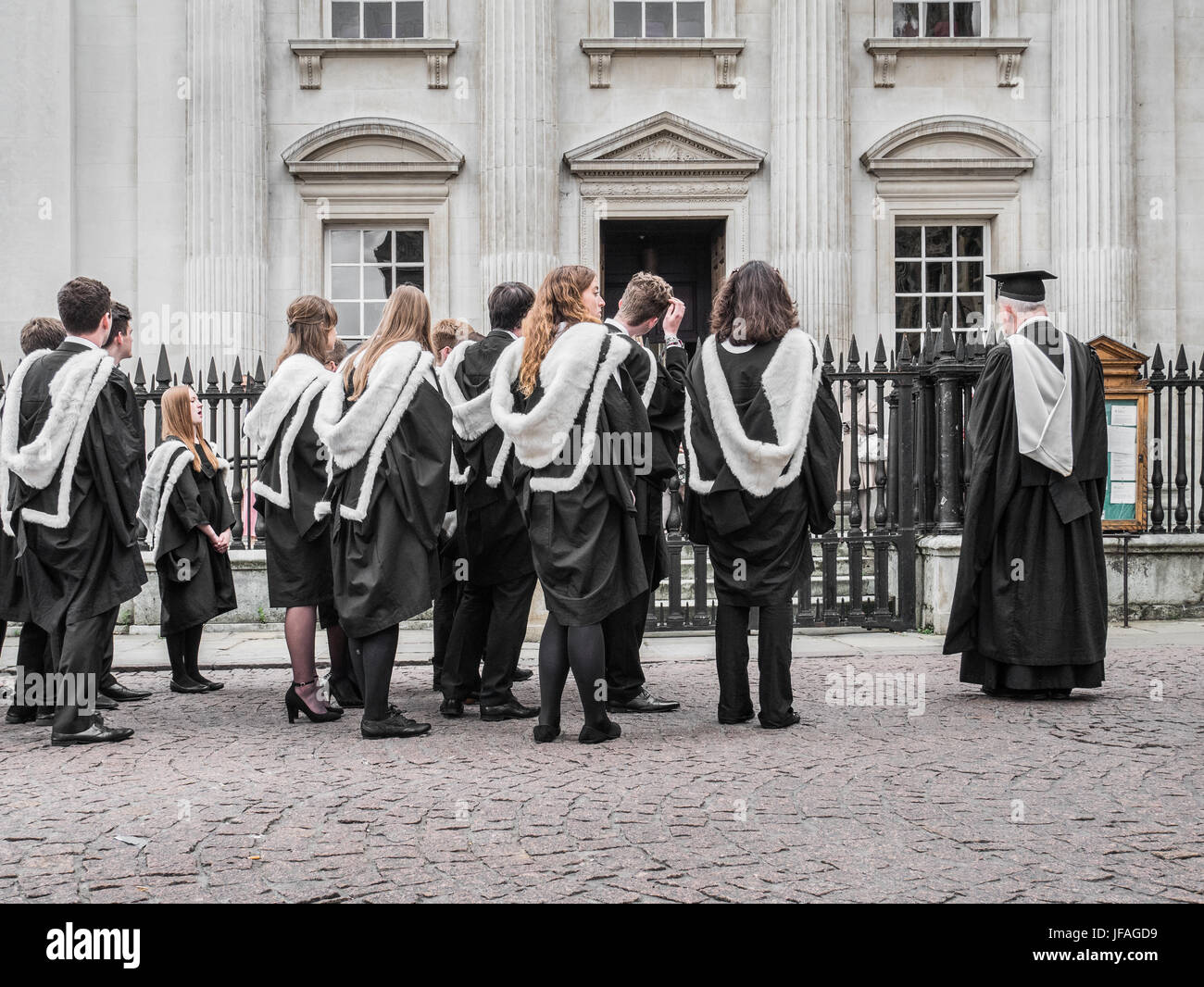 Cambridge, UK. 30 June 2017. Students from Emmanuel College form an orderly queue as they wait on a cobbled street to enter Senate House, University of Cambridge, England, for their graduation ceremony on Friday 30 June 2017. Credit: Michael Foley/Alamy Live News Credit: Michael Foley/Alamy Live News Stock Photo