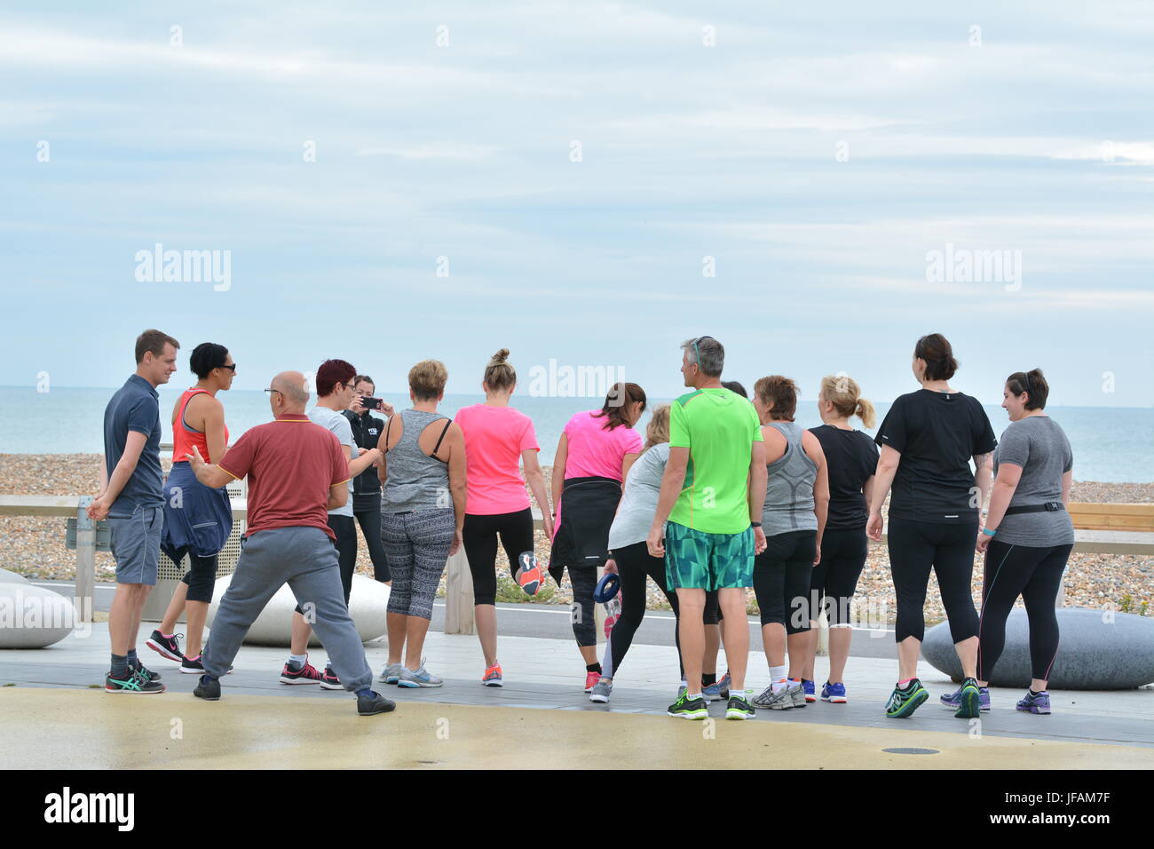 People exercising at an outdoor fitness class on the seafront promenade in Worthing, West Sussex, England, UK. Stock Photo