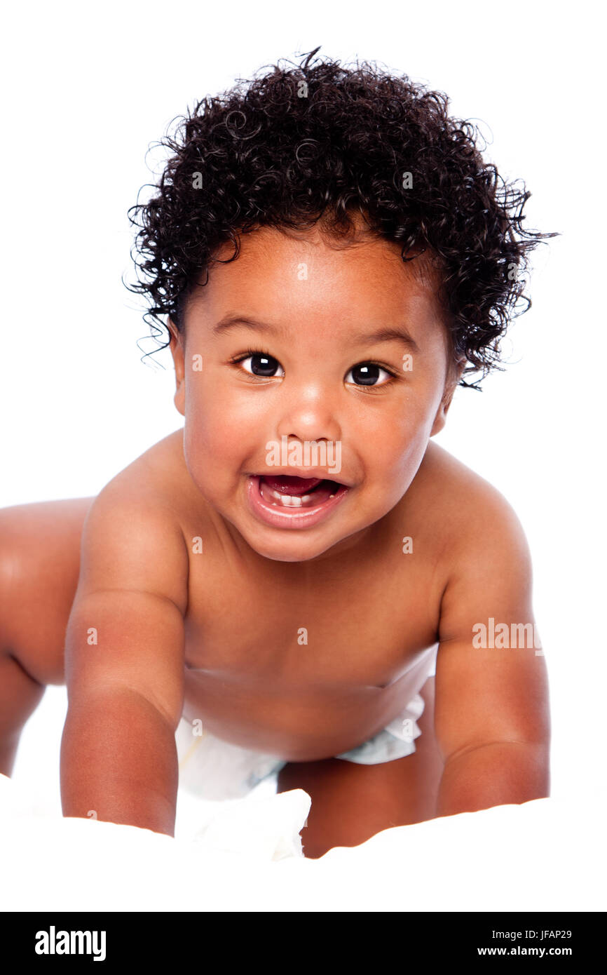 Happy smiling cute adorable teething baby face showing milk teeth, with curly hair, crawling. Stock Photo