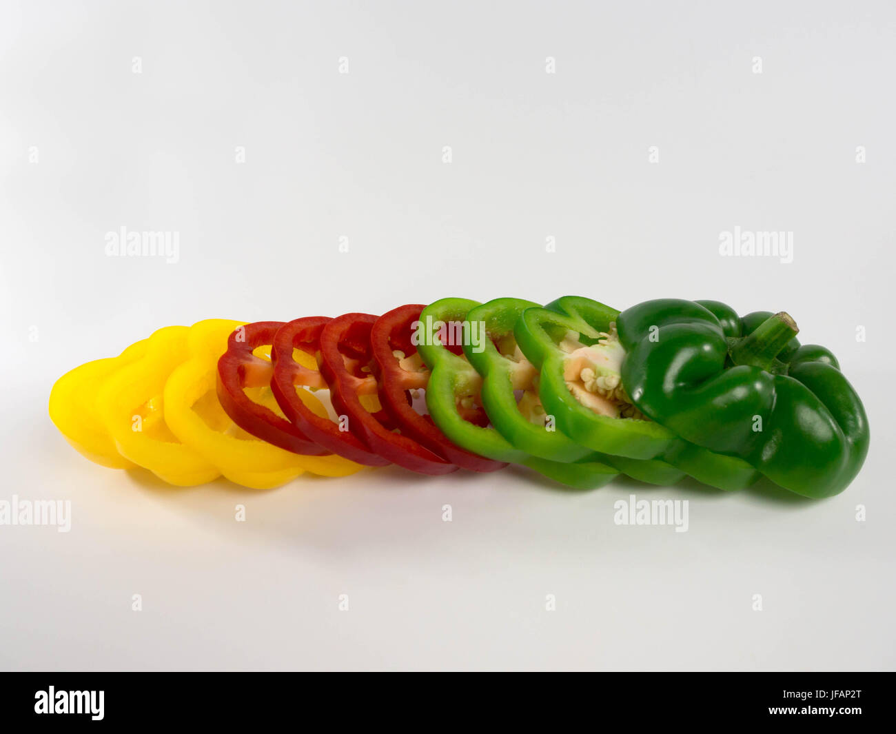 Sliced colored bell peppers arranged on white background Stock Photo ...