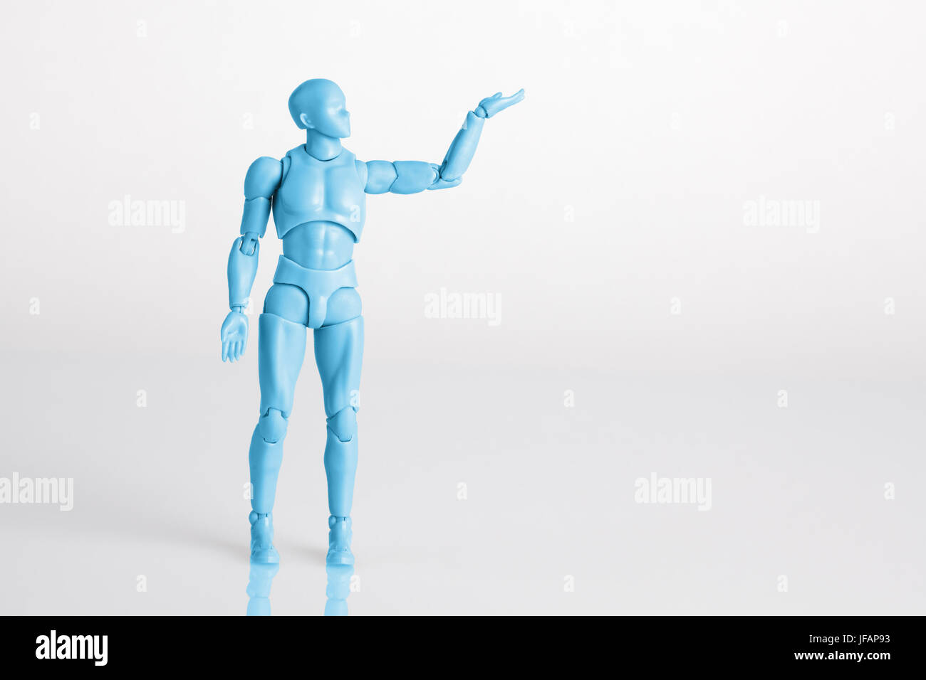 Blue male figurine standing on white reflective table holding one hand up. Making a decision concept with copy space Stock Photo