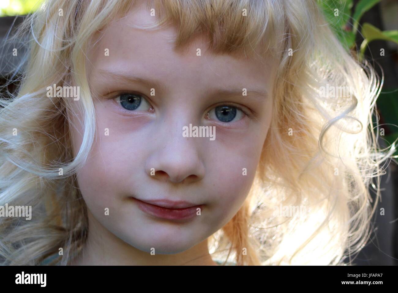 Portrait of fairy like child with golden hair and big blue eyes Stock Photo