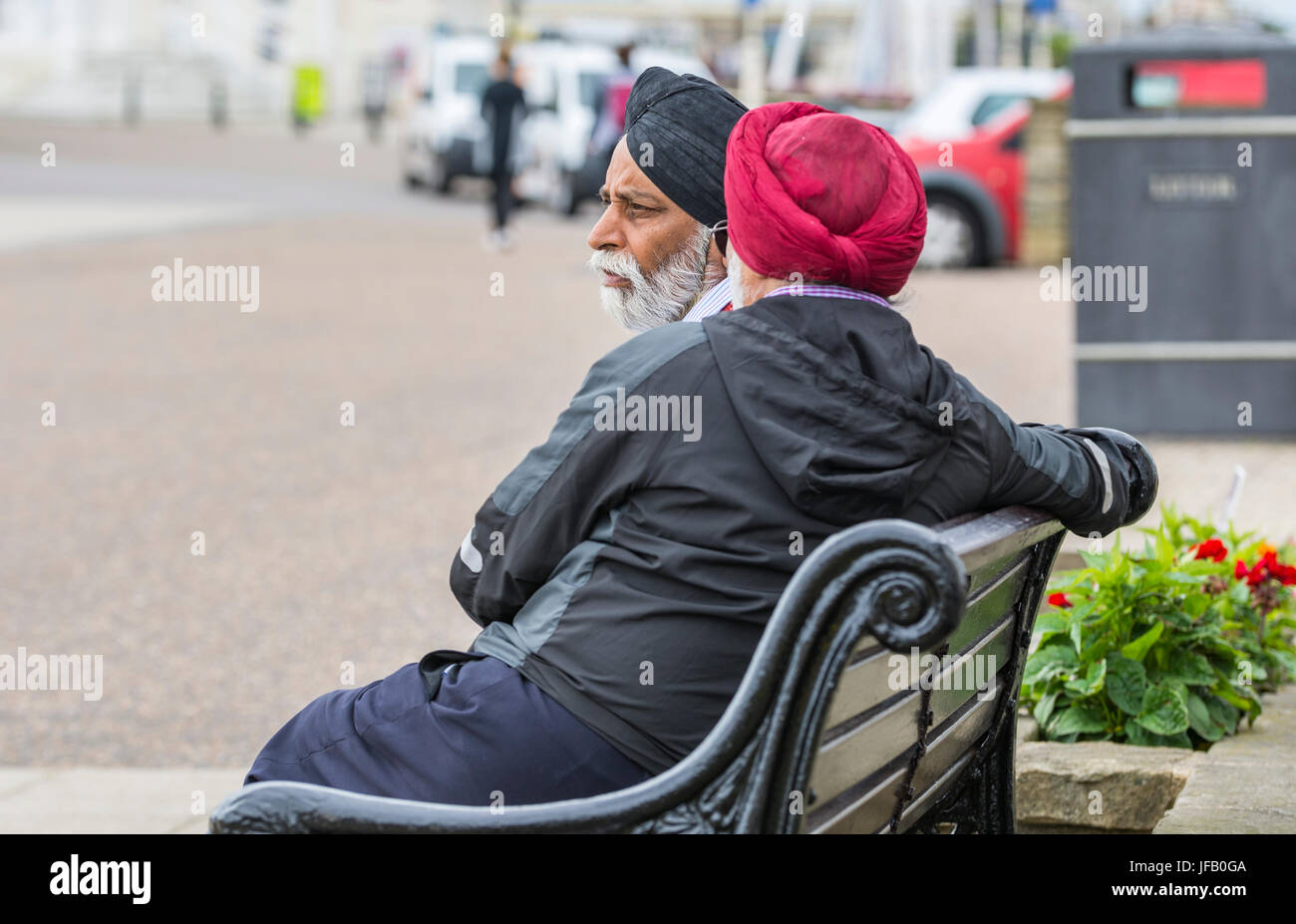 Men wearing turbans sitting on a bench in the UK. Stock Photo