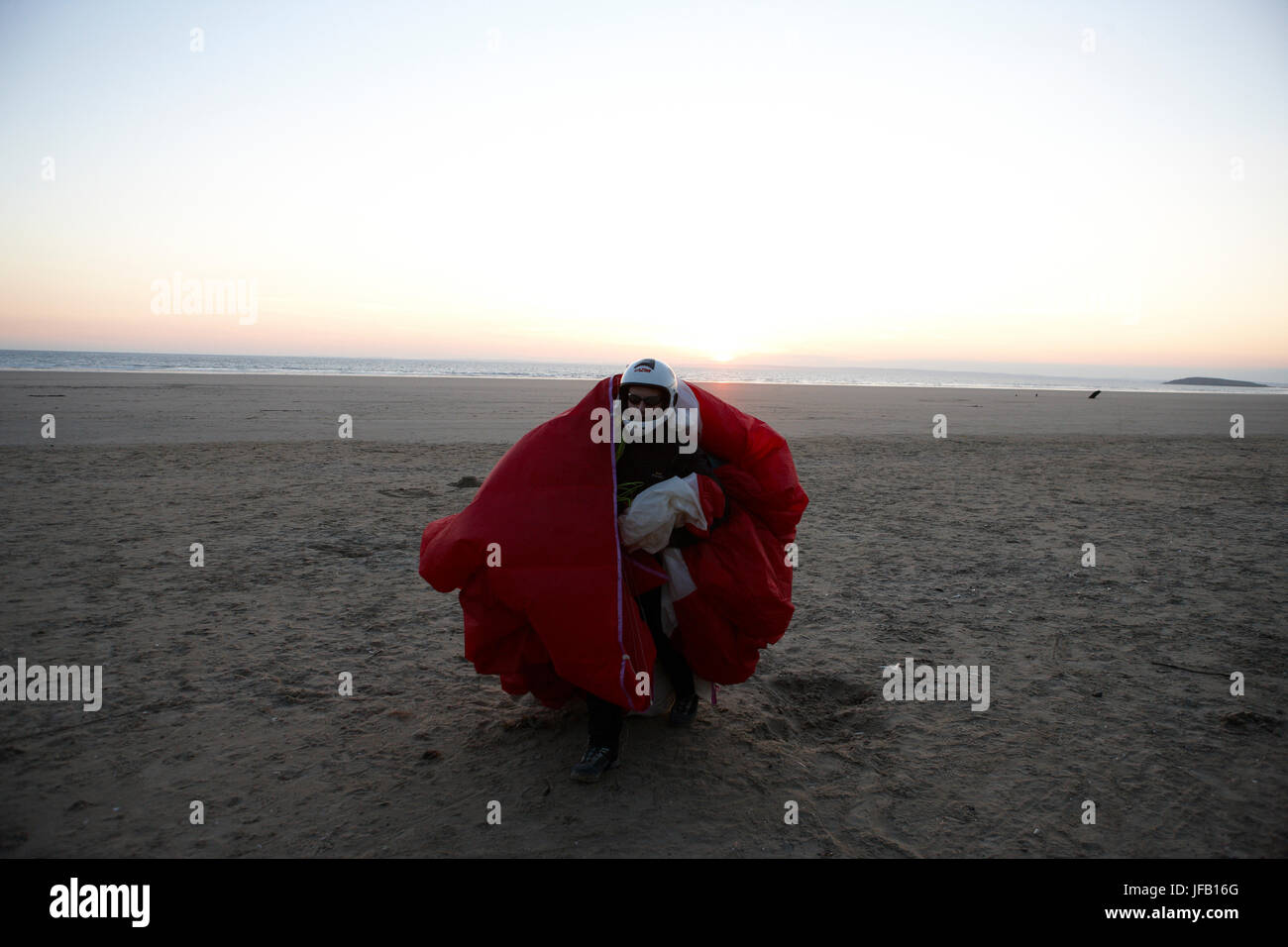 A Paraglider has landed on a beach at sunset, Stock Photo
