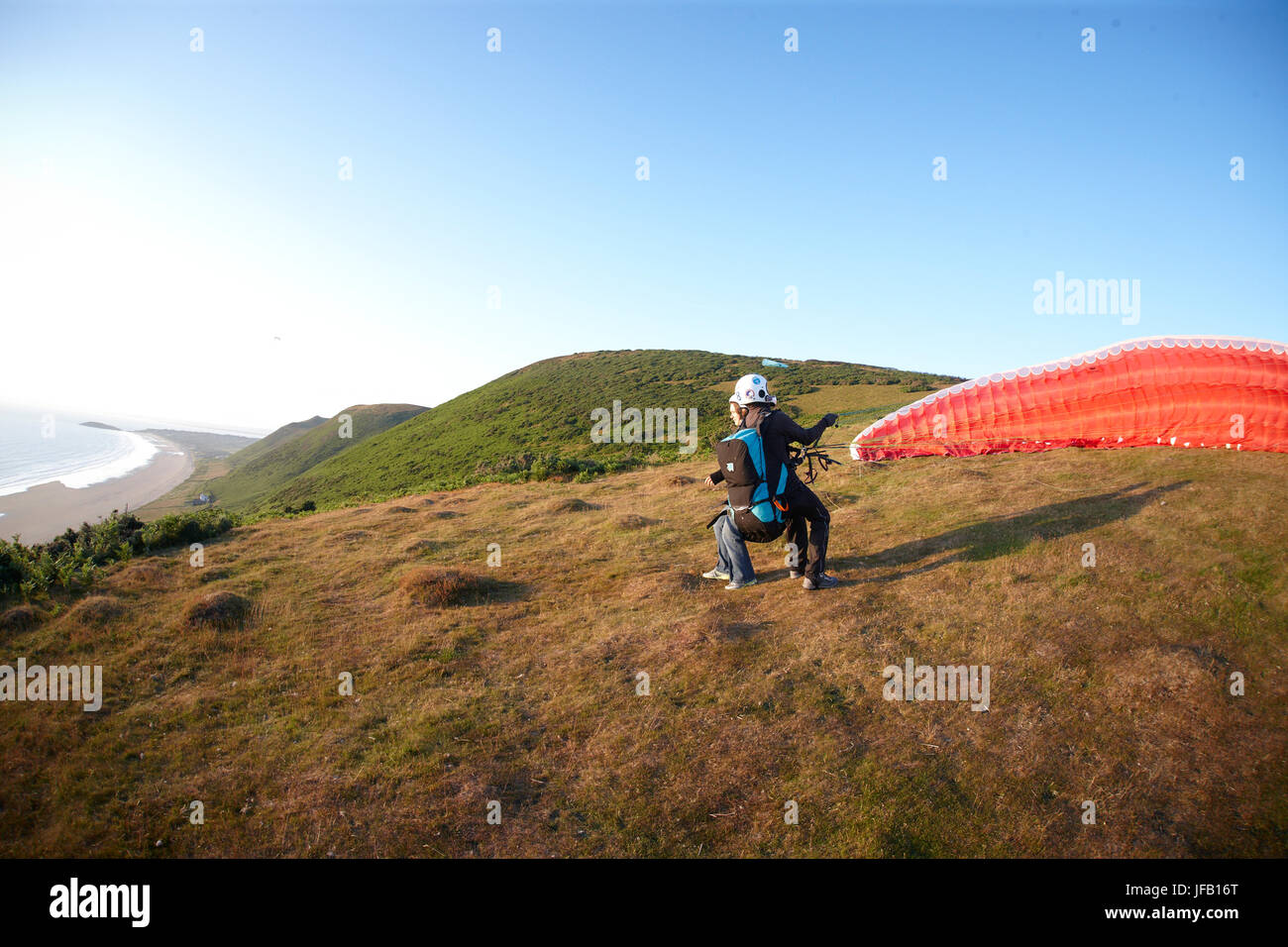 Tandem Paragliders taking off above the beach. Stock Photo