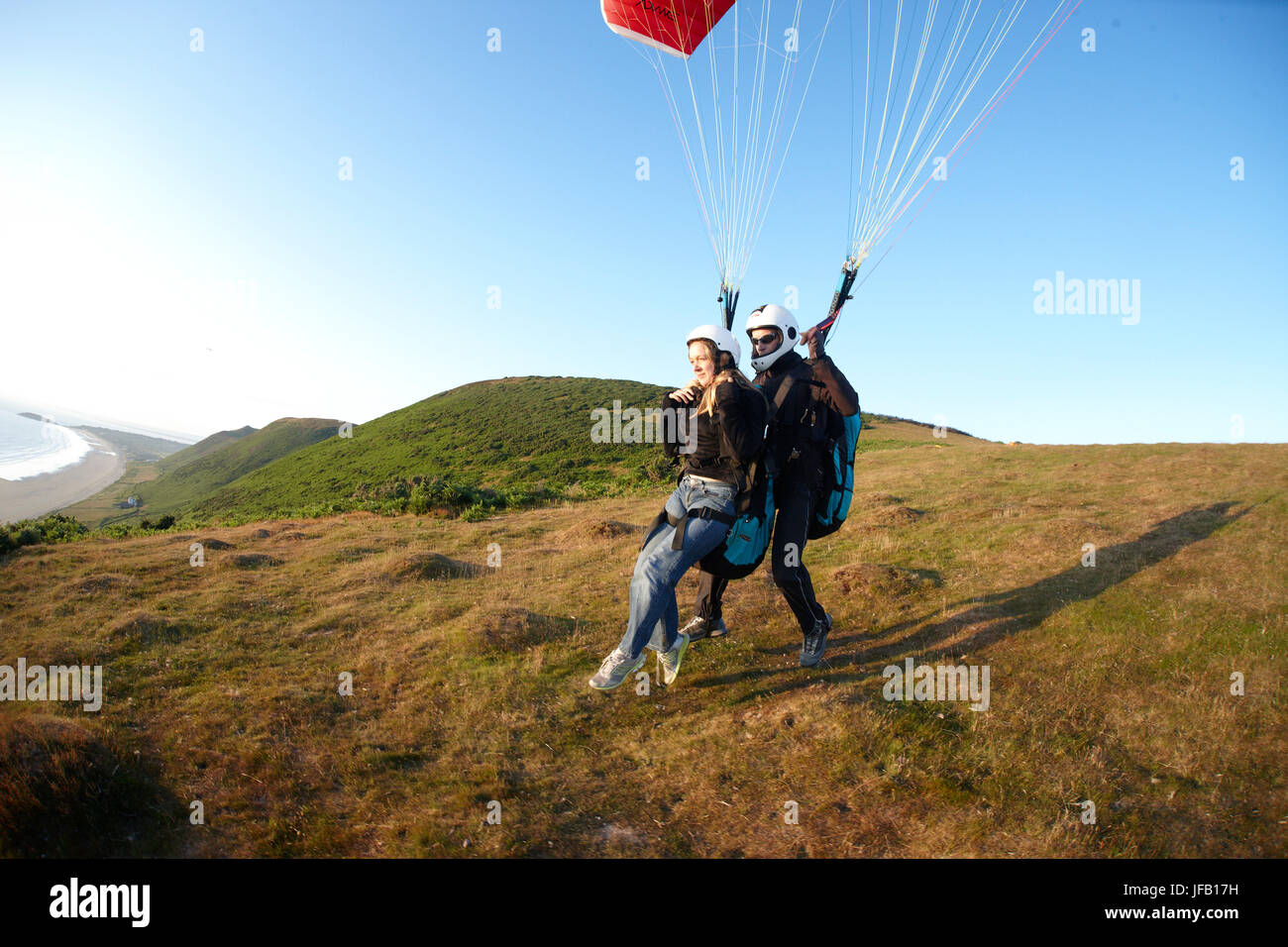 Tandem Paragliders taking off above the beach. Stock Photo