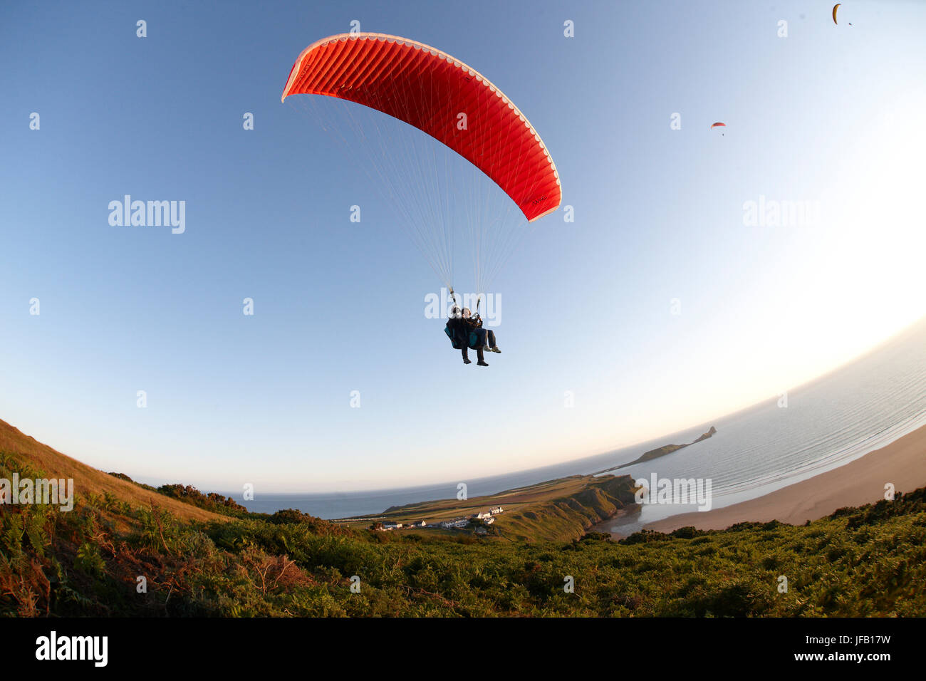 Tandem paragliding over the ocean Stock Photo