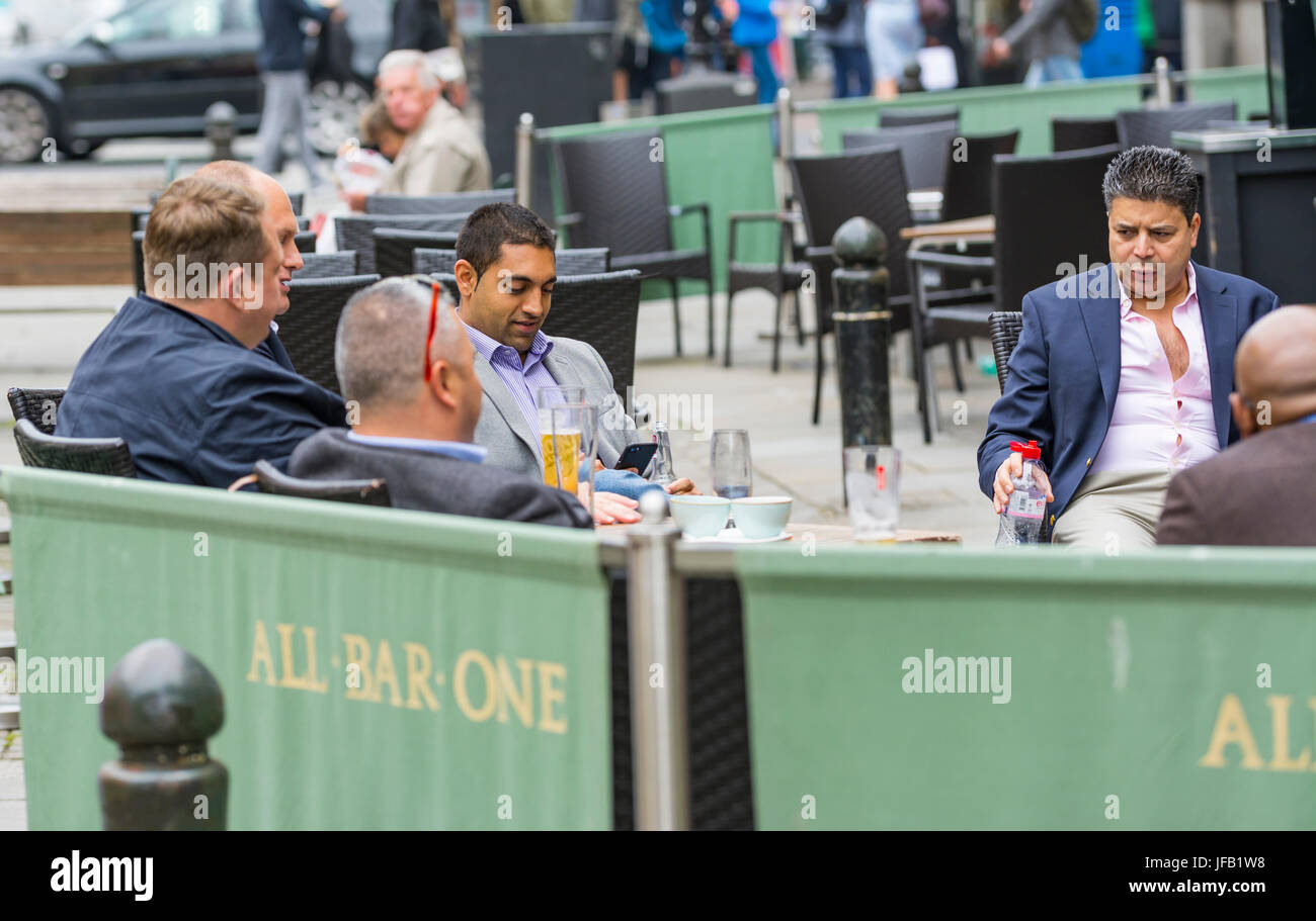 Smart middle aged men in suits sitting outside at a bar in Brighton. Stock Photo