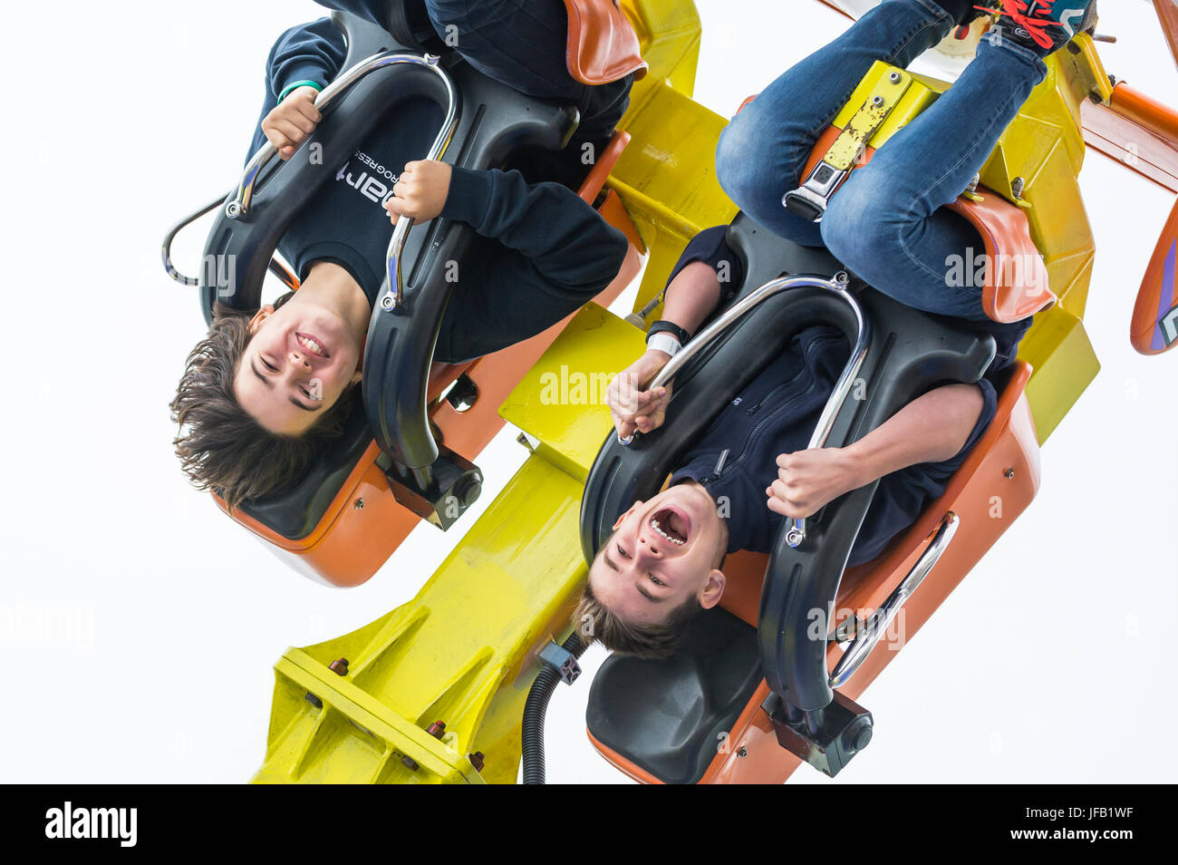 Boys upside down on the Air Race ride on Brighton Pier. Stock Photo